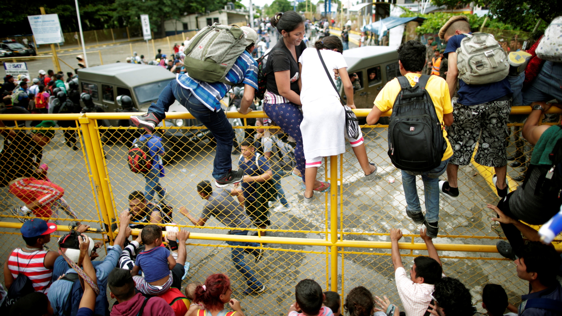 Migranten aus Honduras überqueren einen Grenzzaun zwischen Mexiko und Guatemala | Bildquelle: REUTERS