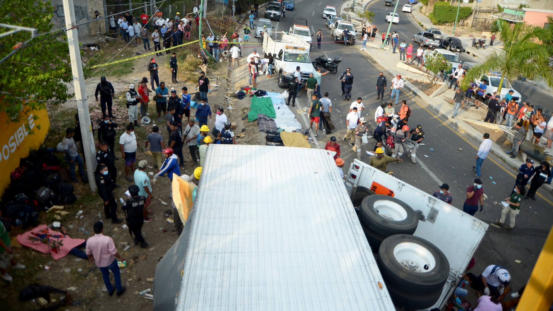 Menschen stehen an der Unfallstelle, nachdem ein Lkw mit mehr als 100 mexikanischen Migranten verunglückte. | REUTERS
