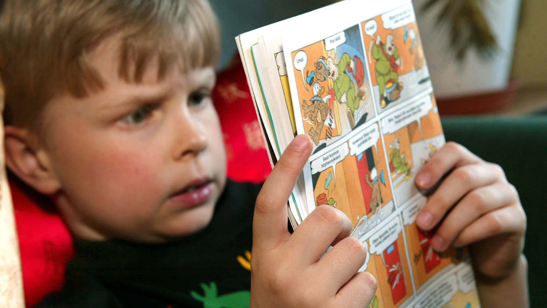 Ein Siebenjähriger liest ein Micky-Maus-Heft. | picture-alliance / dpa