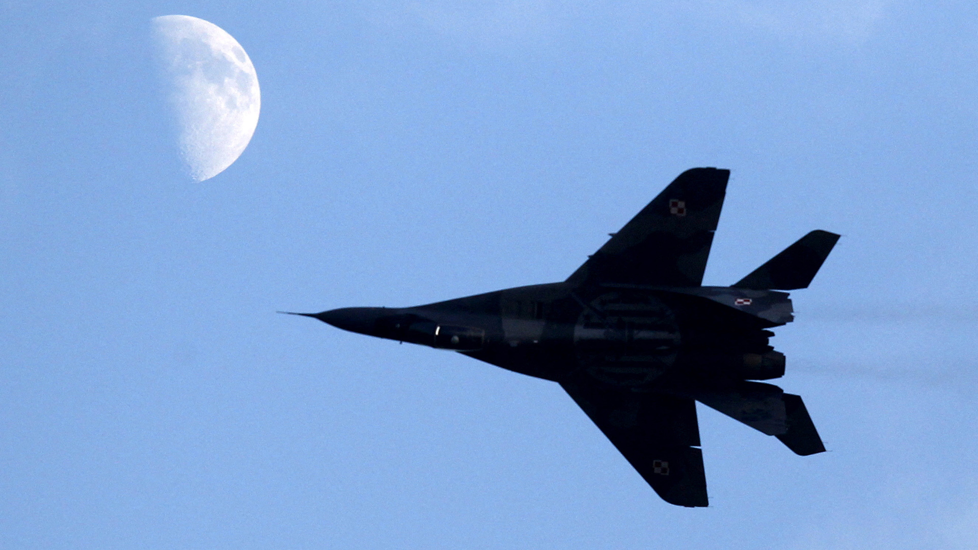 Ein polnischer Kampfjet  MiG-29 in der Luft, im Hintergrund ist der Mond zu sehen. | REUTERS