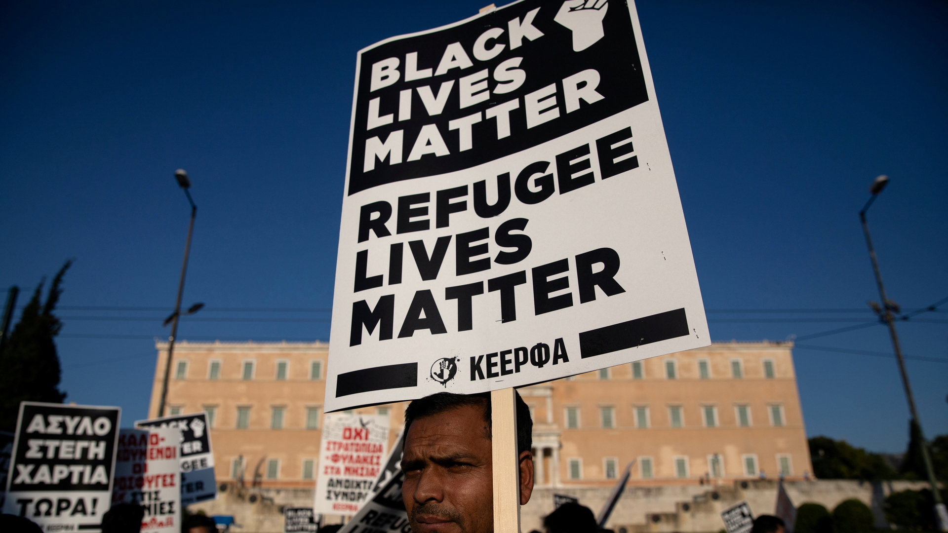 "Schwarze Leben zählen" und "die Leben von Geflüchteten zählen" steht auf dem Protestplakat eines Demonstranten in Athen (Archivbild vom Juni 2020). | REUTERS
