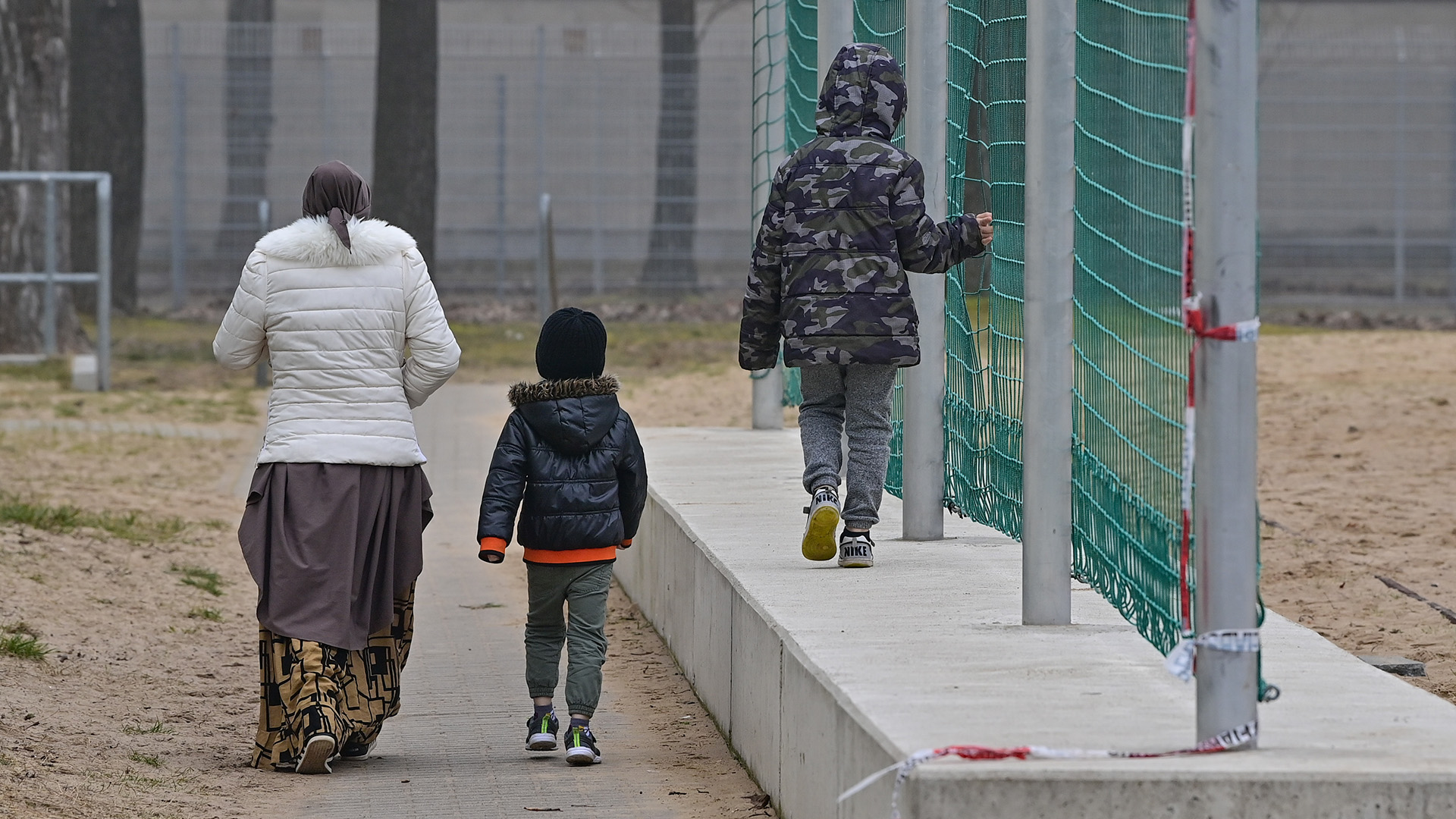 Migranten gehen über das Gelände der Zentralen Erstaufnahmeeinrichtung für Asylbewerber des Landes Brandenburg. | picture alliance/dpa/dpa-Zentral