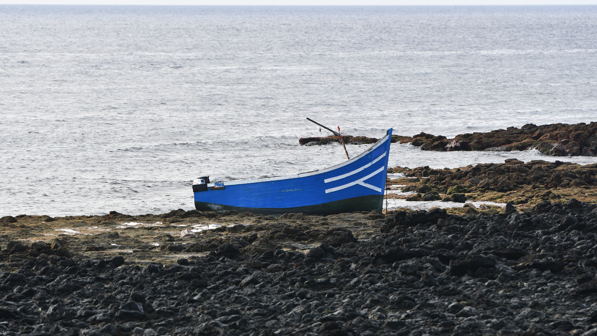 Ein Boot, mit dem Migranten Spanien erreicht haben, liegt am Strand von Las Caletas auf Lanzarote.  | dpa