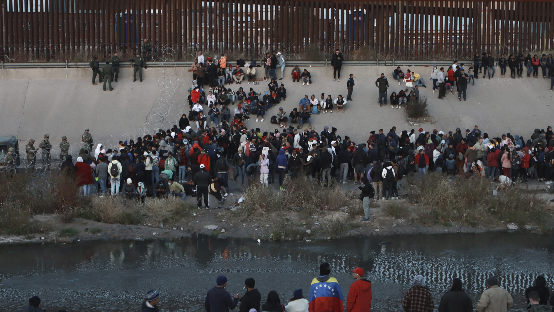 Migranten stehen an einem Grenzübergang zwischen El Paso, Texas und Ciudad Juarez, Mexiko. (Archivbild: Dezember 2022) | picture alliance/dpa/AP