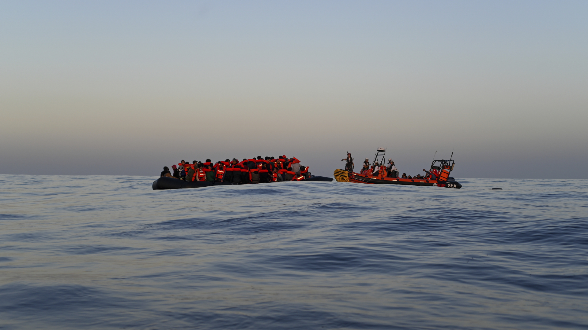 Ein Rettungsteam der humanitären Organisation Ärzte ohne Grenzen (MSF) nähert sich einem Schlauchboot mit 74 Migranten an Bord, um sie auf das Rettungsschiff Geo Barents im Mittelmeer zu bringen (Archivbild). | dpa