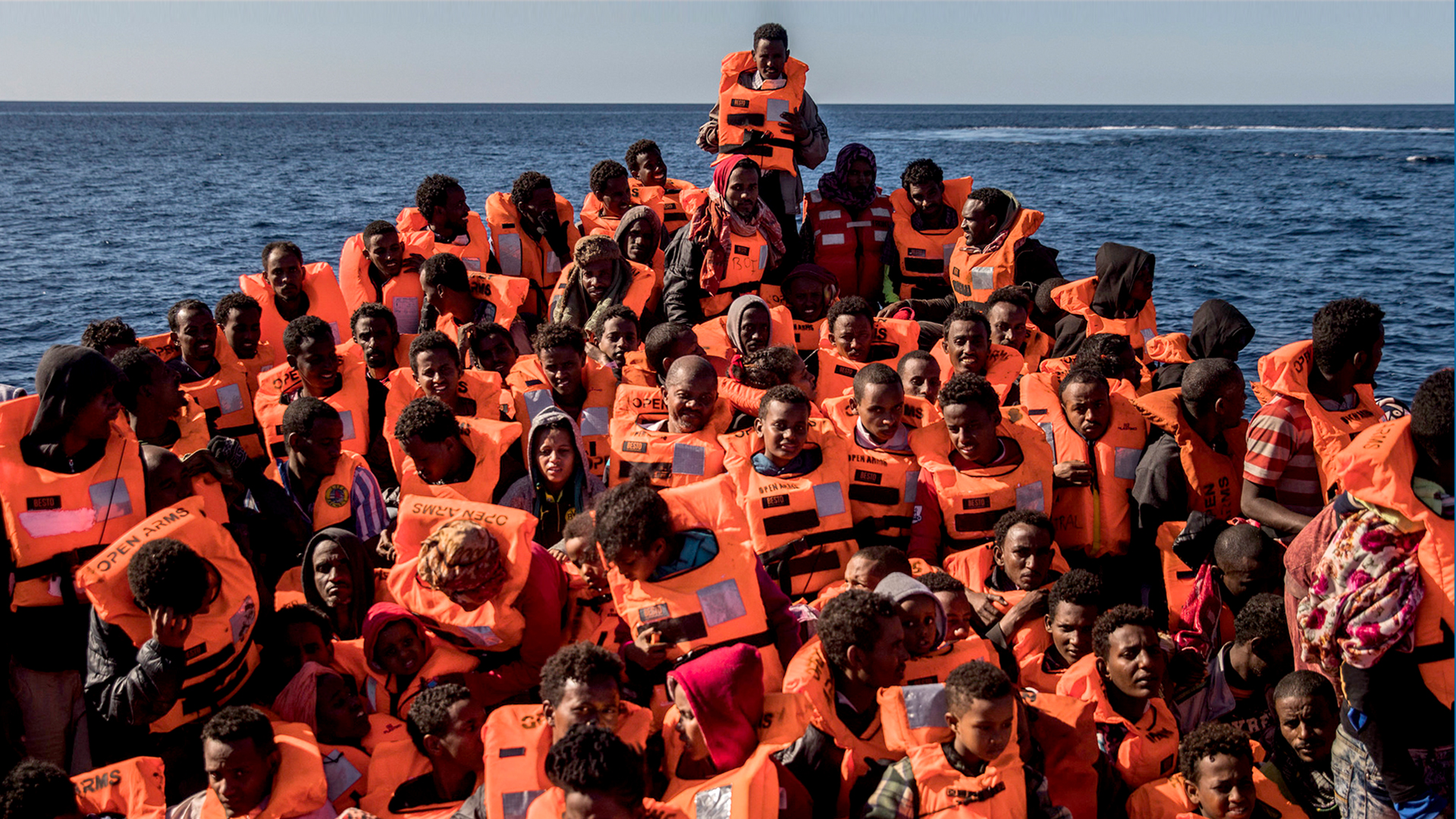Mehrere Flüchtlinge aus verschiedenen afrikanischen Ländern sitzen vor der Küste von Libyen an Bord eines überfüllten Holzbootes | dpa