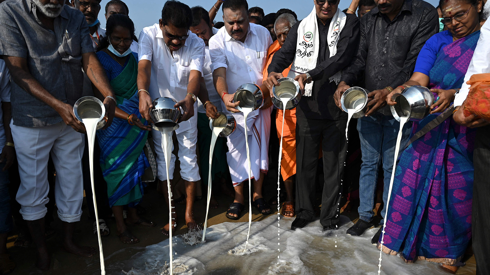 Menschen gießen Milch ins Meer, Chennai (Indien). | AFP