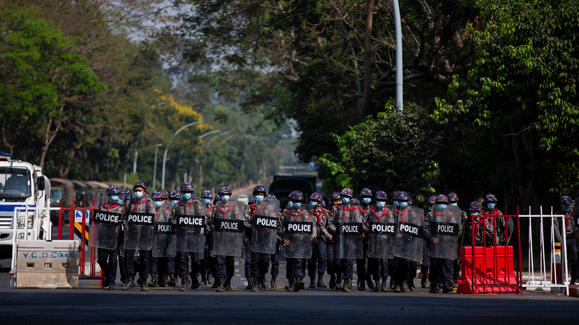 Polizisten gehen in Formation auf einer Straße in Myanmar. | picture alliance/dpa/SOPA Images