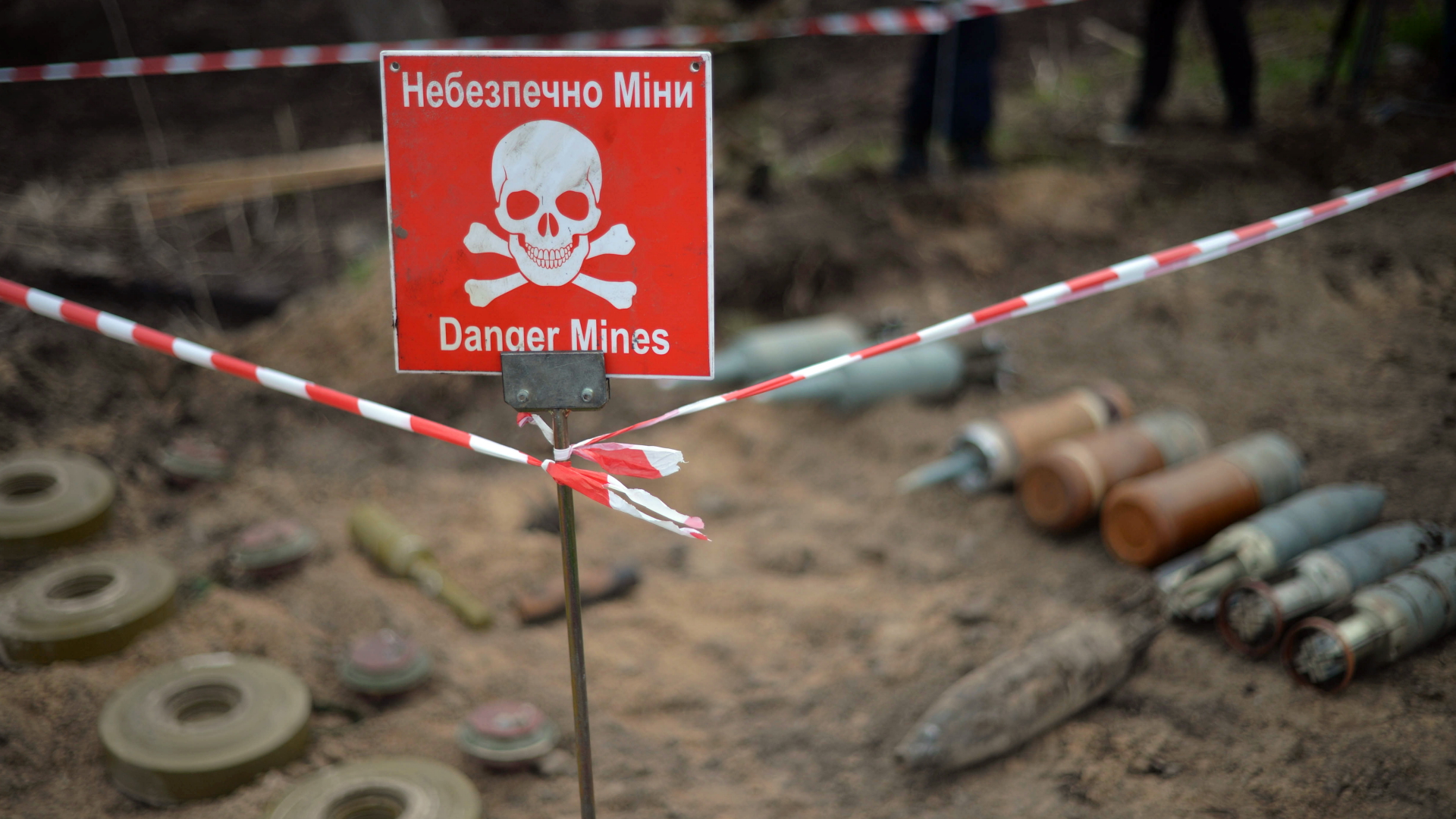 Ein Minen-Warnschild und geborgene Minen und Munition im Dorf Bervytsia nahe Kiew. | dpa