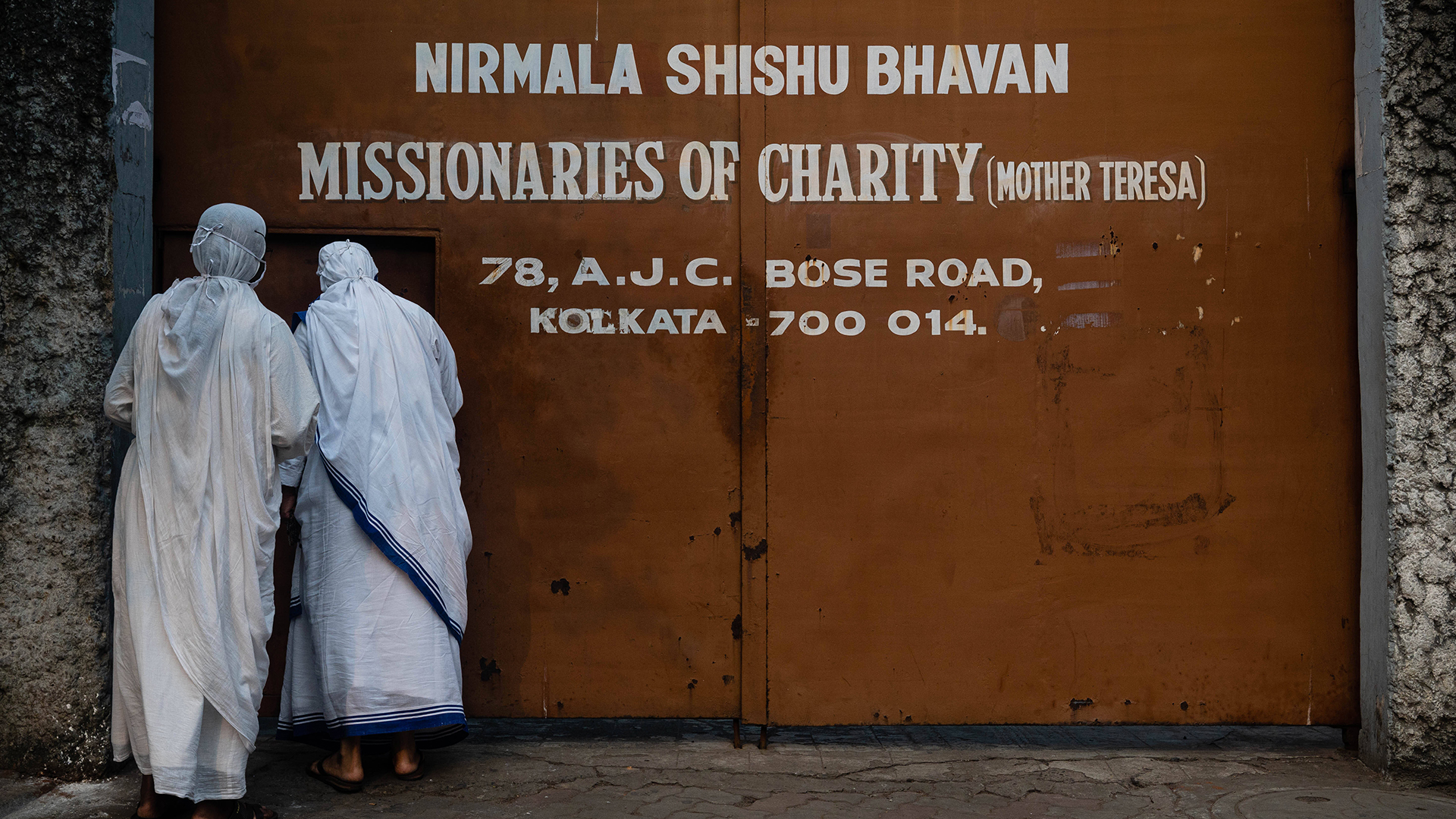 Zwei Frauen gehen zum Eingangstor der Missionare der Wohltätigkeit in Kalkutta.  | imago images/ZUMA Wire