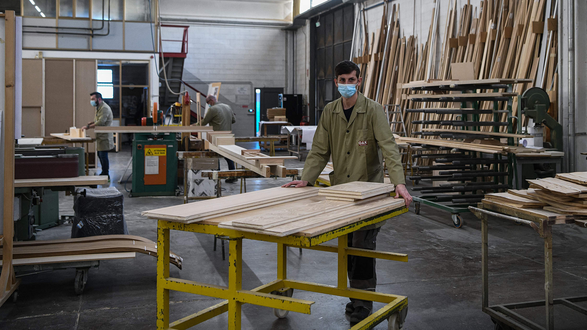 Drei Männer arbeiten in einer Möbelwerkstatt. | AFP