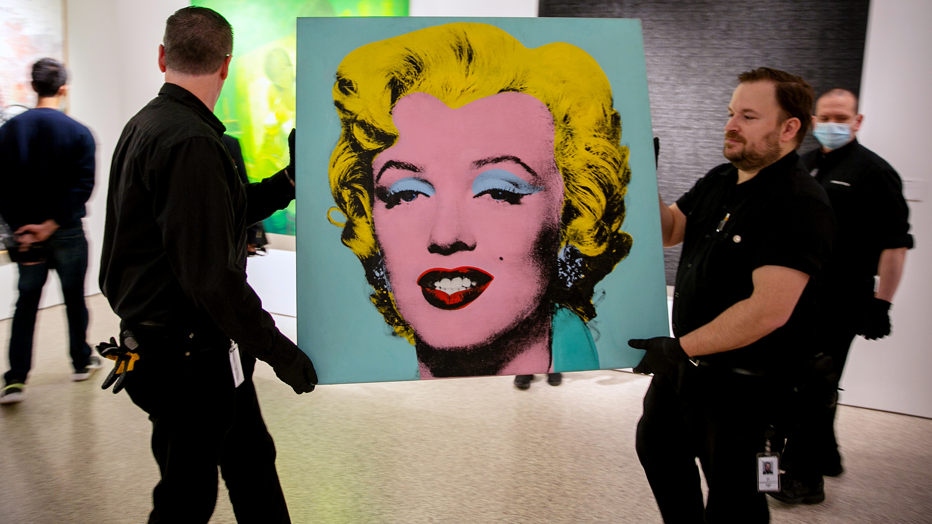 Das Gemälde "Shot Sage Blue Marilyn" von Andy Warhol aus dem Jahr 1964 wird in den Ausstellungsraum von Christie's getragen.  | dpa