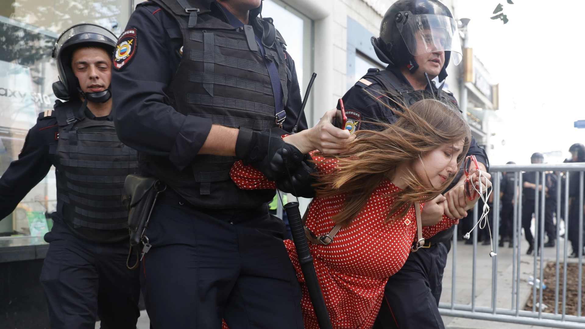 Polizisten führen eine Frau während einer nicht genehmigten Kundgebung im Zentrum von der Stadt ab. | dpa