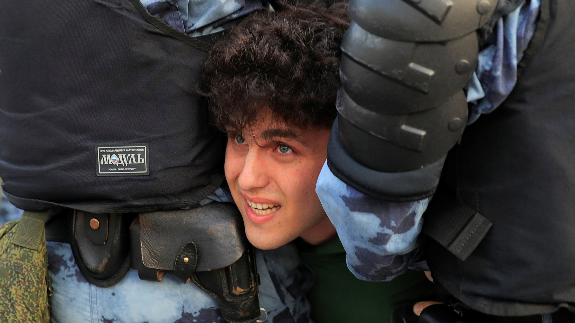 Ein Demonstrant wird von Polizisten gewaltsam festgehalten