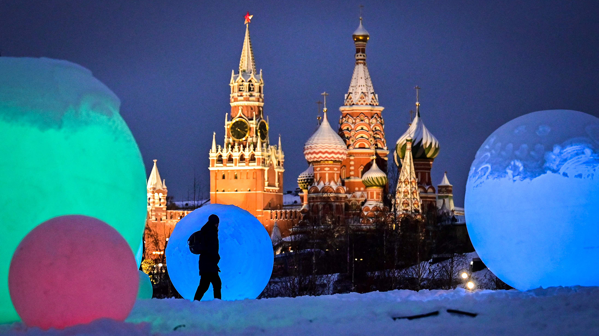 Ein Fußgänger geht an einer Weihnachtsdekoration im Moskauer Sarjadje-Park vor dem Kreml und der Basilius-Kathedrale vorbei. | AFP
