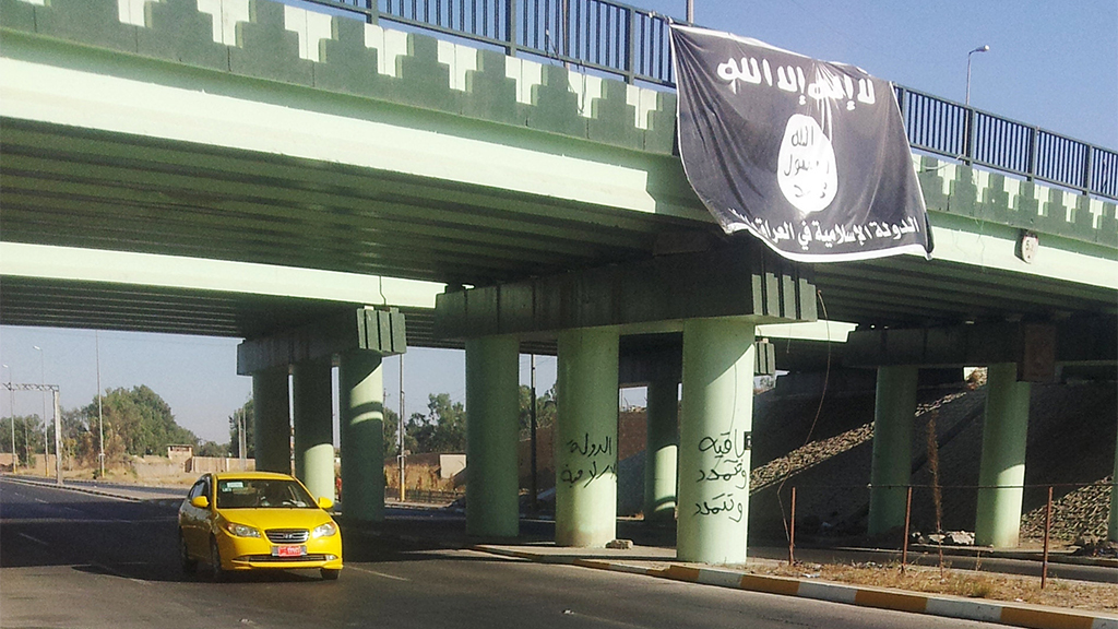 Eine IS-Flagge hängt an einer Brücke in Mossul, Bild vom Juli 2014. | AP