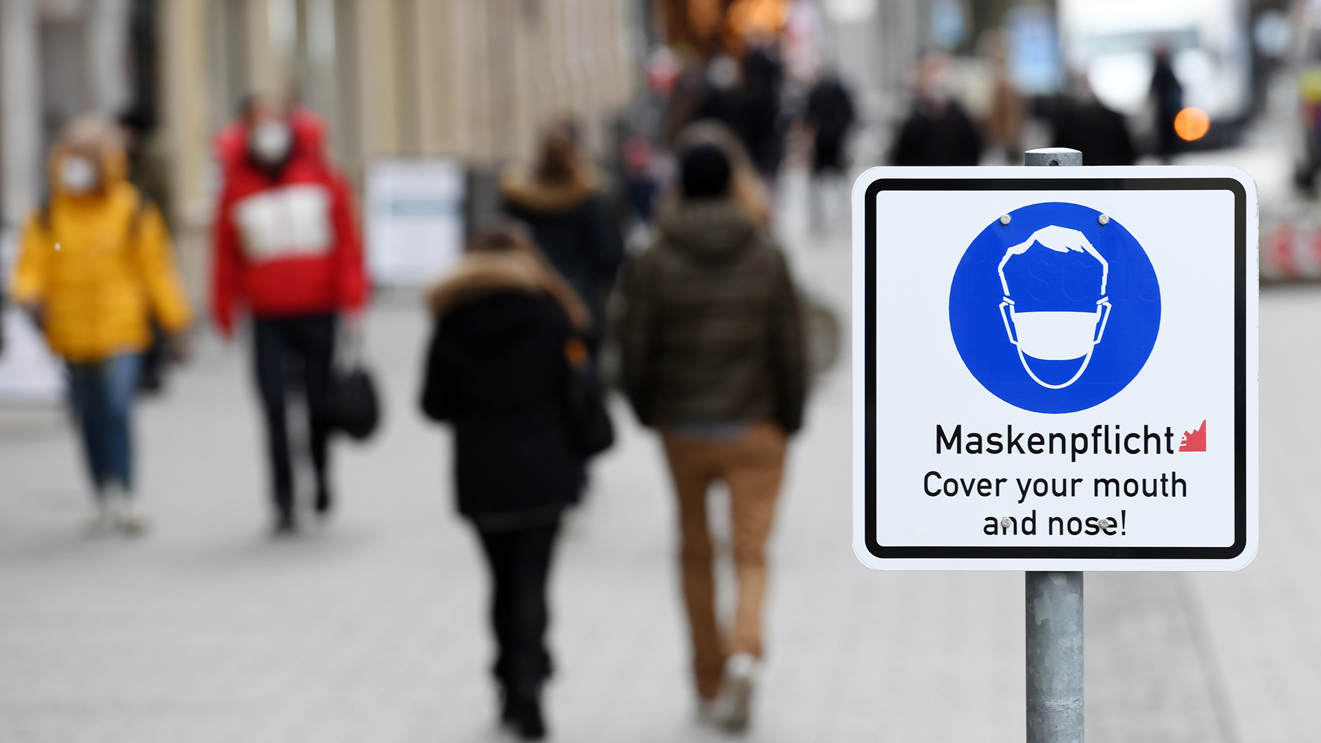 Ein Schild weist in der Münchner Innenstadt auf die Maskenpflicht innerhalb der Fußgängerzone hin. | dpa