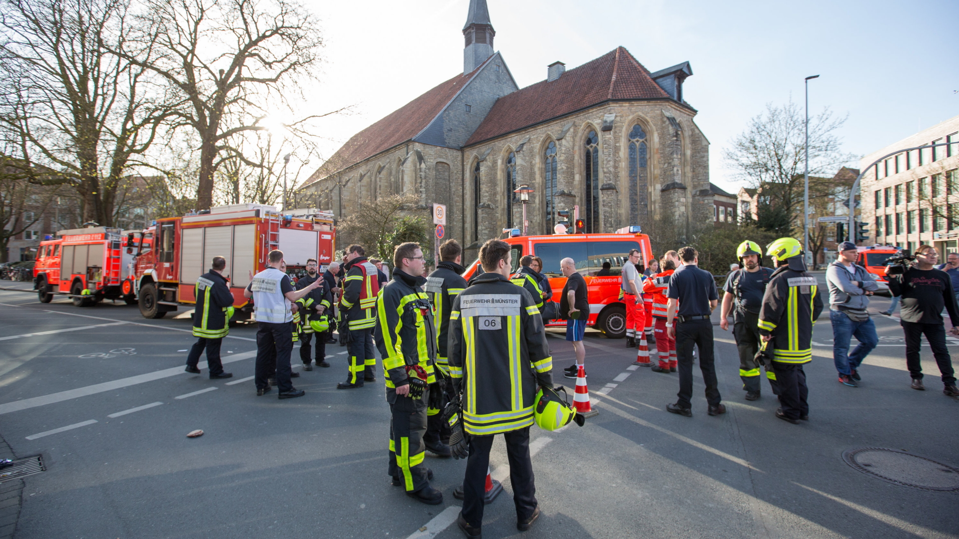  Feuerwehrleute stehen in der Innenstadt von Münster. 