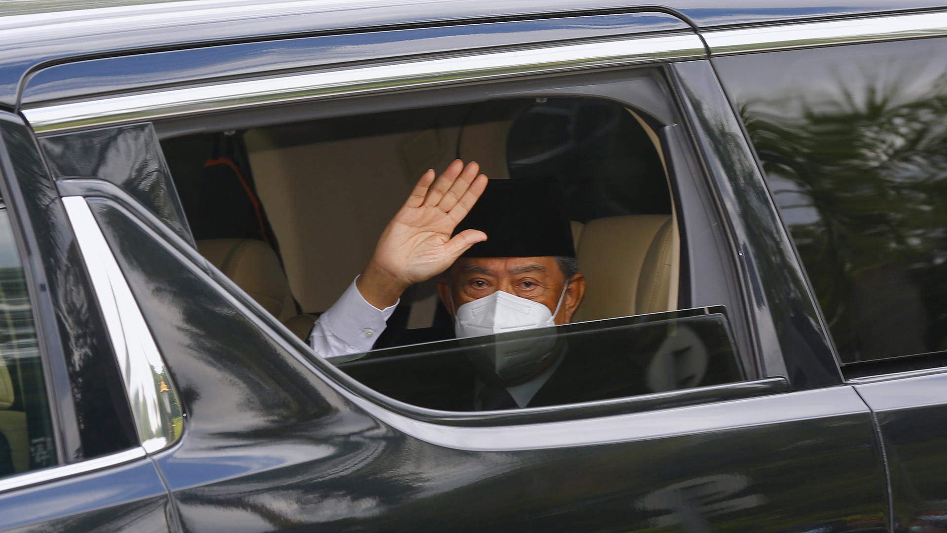 Muhyiddin Yassin winkt aus einem offenen Autofenster heraus. | EPA