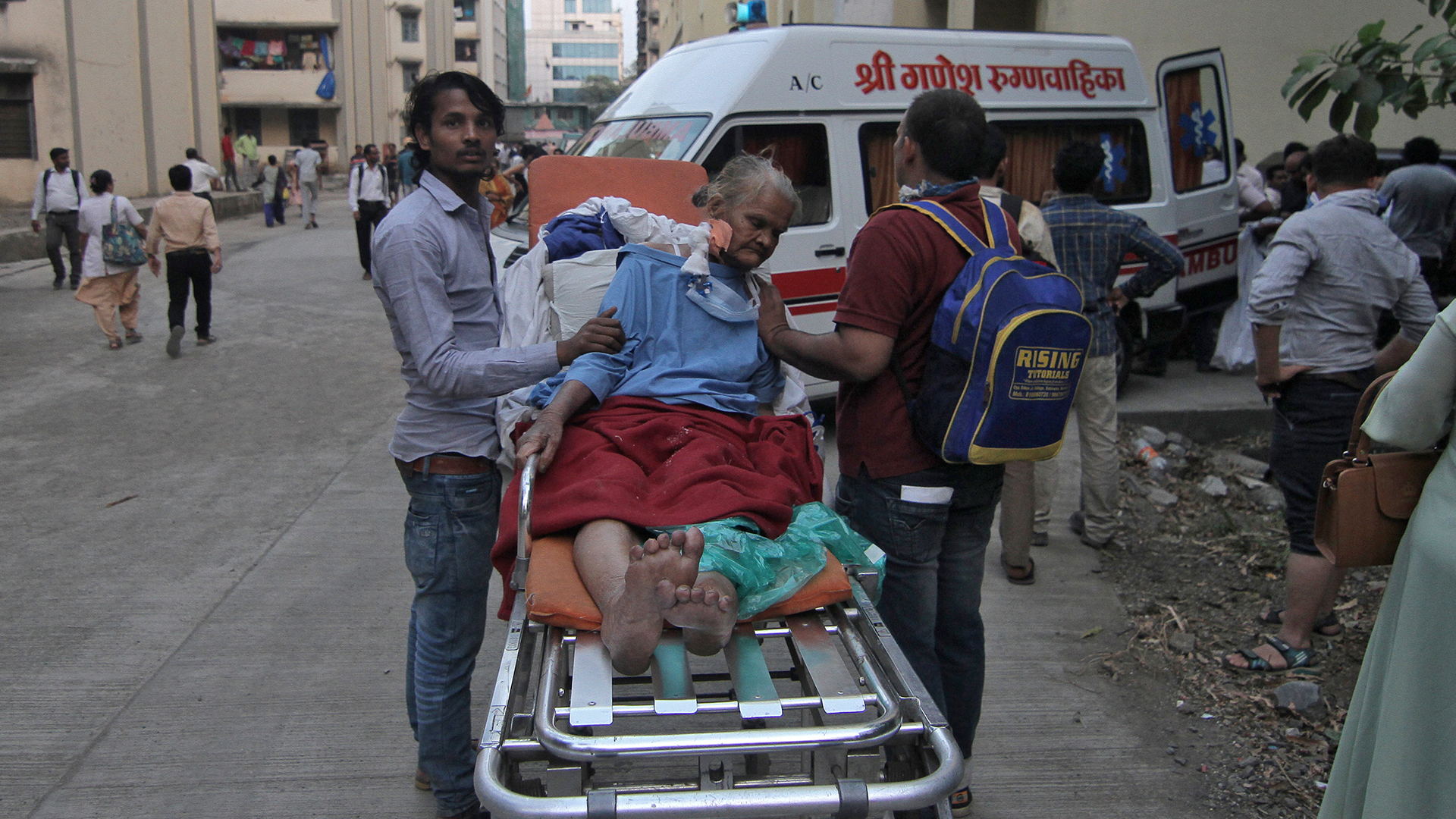 Eine ältere Dame auf einer Krankenliege mit zwei Helfern | Bildquelle: REUTERS