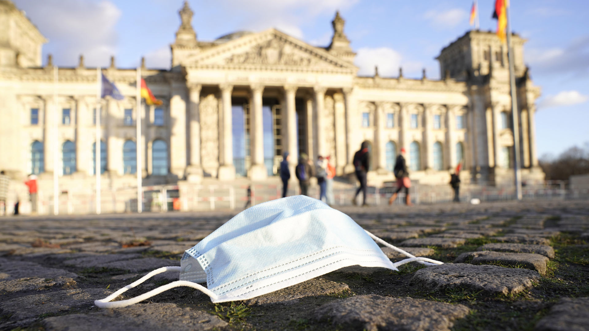 Ein Mund-Nasenschutz liegt vor dem Deutschen Bundestag auf dem Boden. | picture alliance / Flashpic