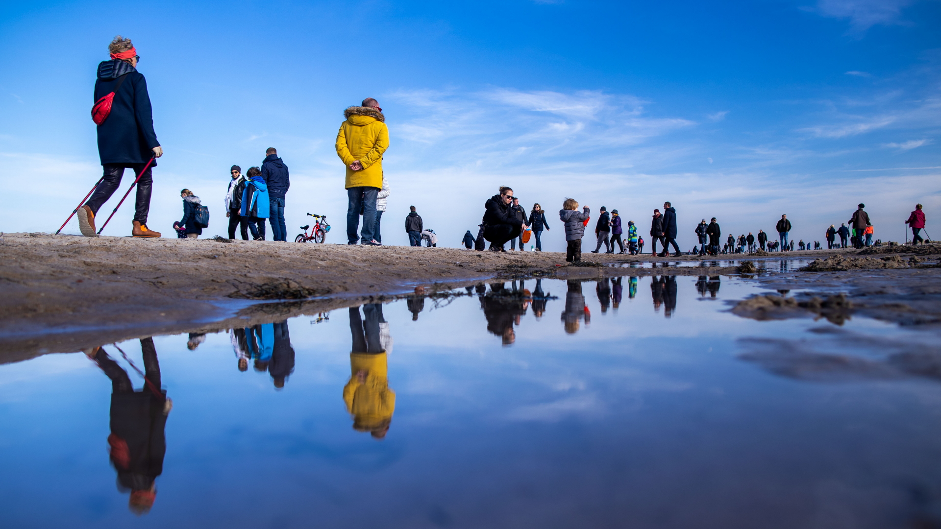 Spaziergänger sind am Strand von Warnemünde an der Ostsee unterwegs. | dpa