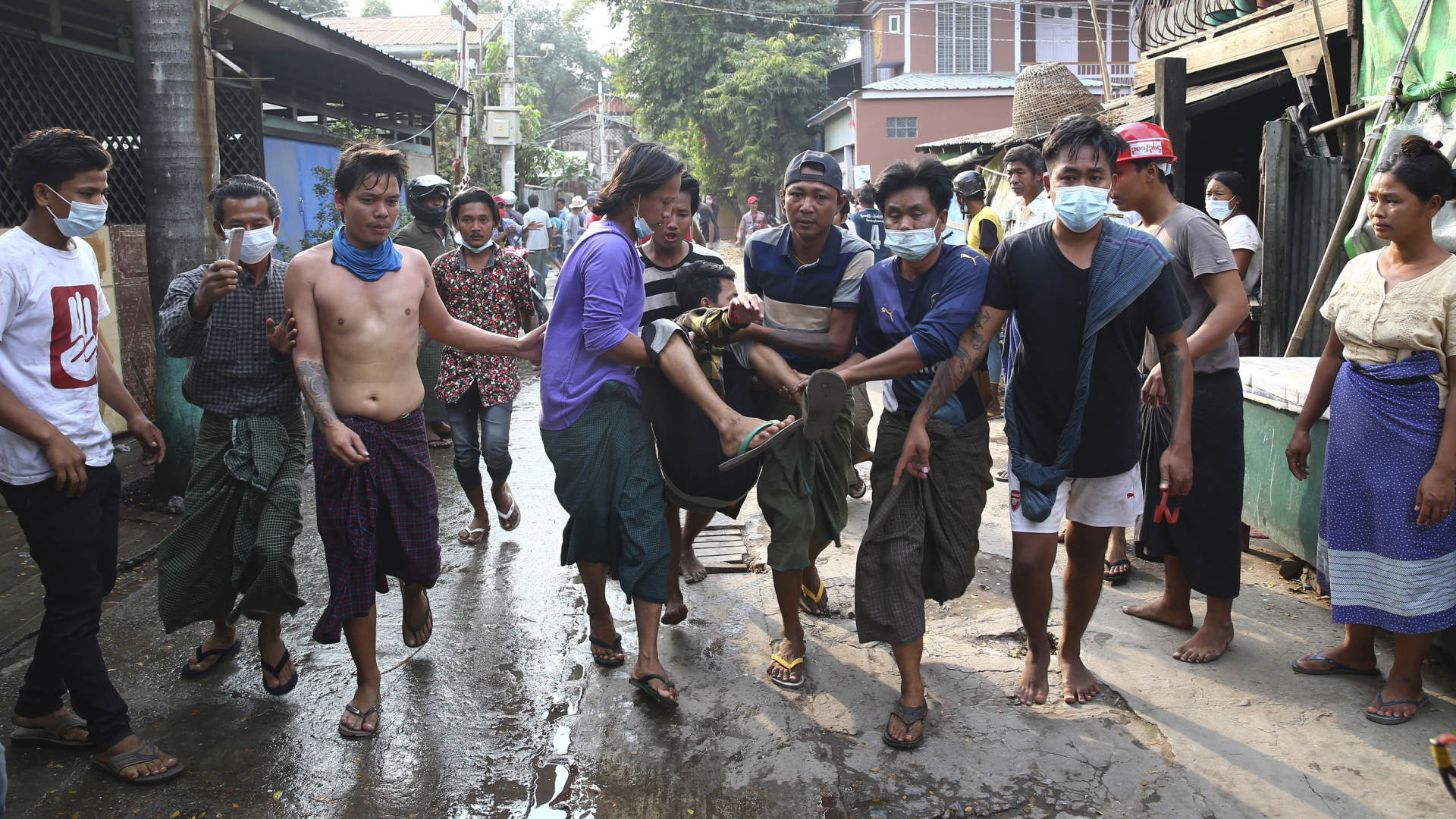 Ein Mann wird weggetragen nachdem die Polizei in Mandalay, Myanmar, Demonstranten mit Schüssen vertrieben hat. | AP