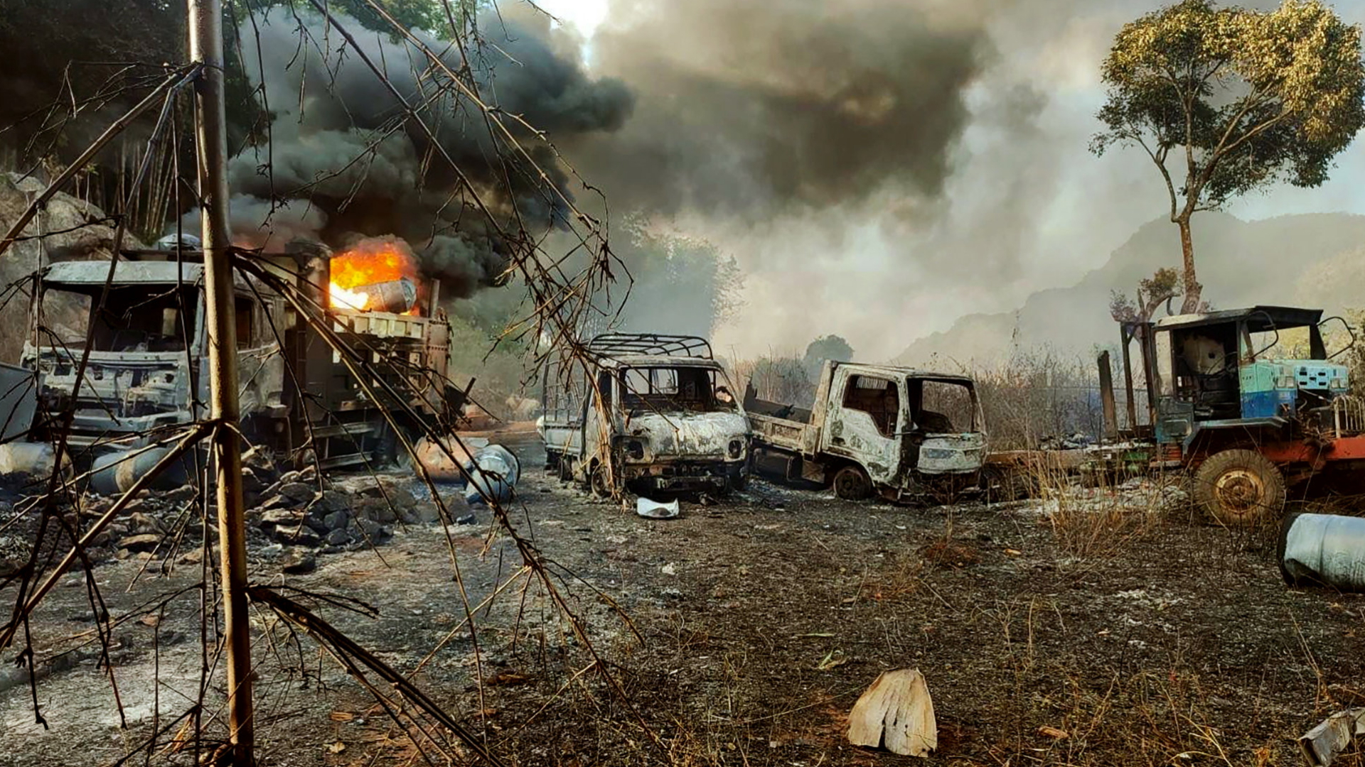 Brennende Autos nach einem Angriff von Regierungstruppen auf Dorfbewohner in Myanmar. | AP