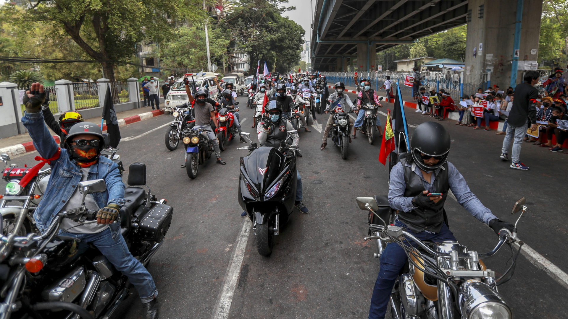 Demonstrierende auf Motorrädern blockieren in Rangun eine Straße und zeigen den Drei-Finger-Gruß. | AP