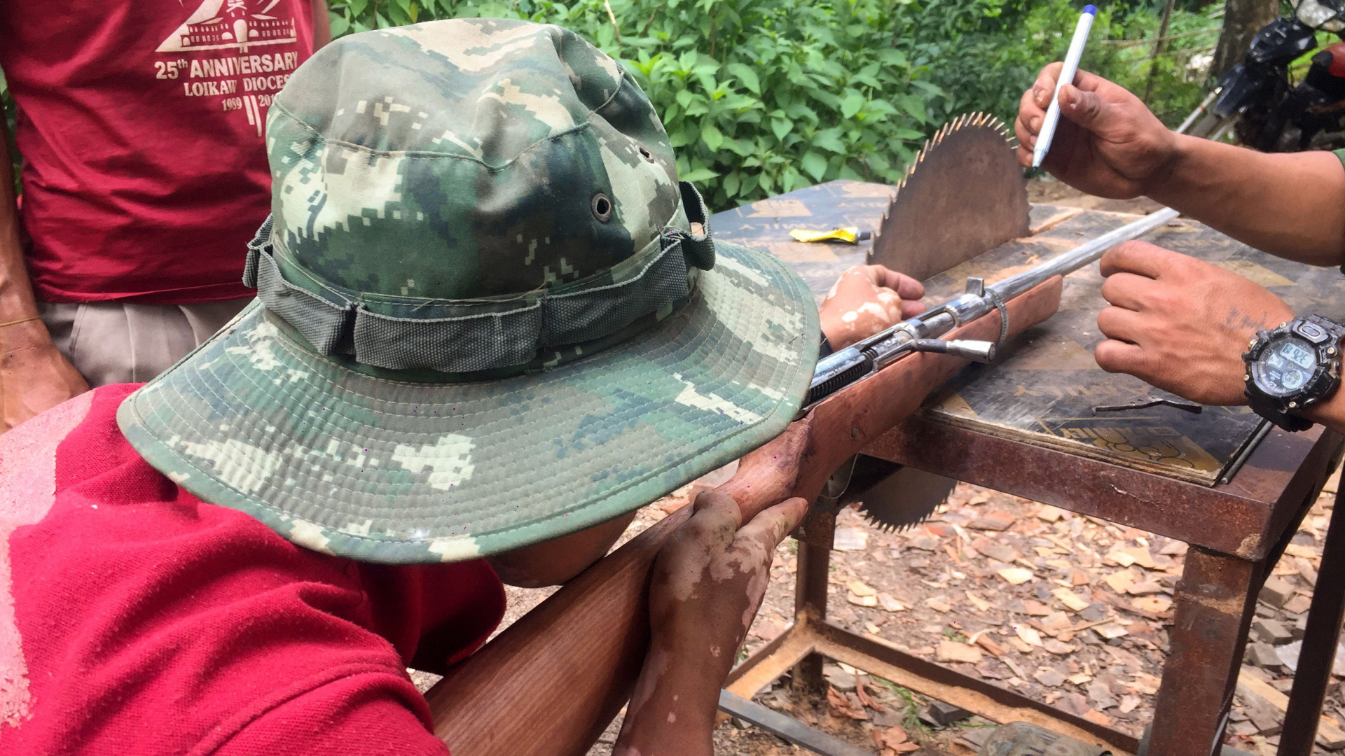 Kämpfer der "People's Defence Force" basteln am Sägeblatt eine selbstgebaute Waffe zurecht. | AFP