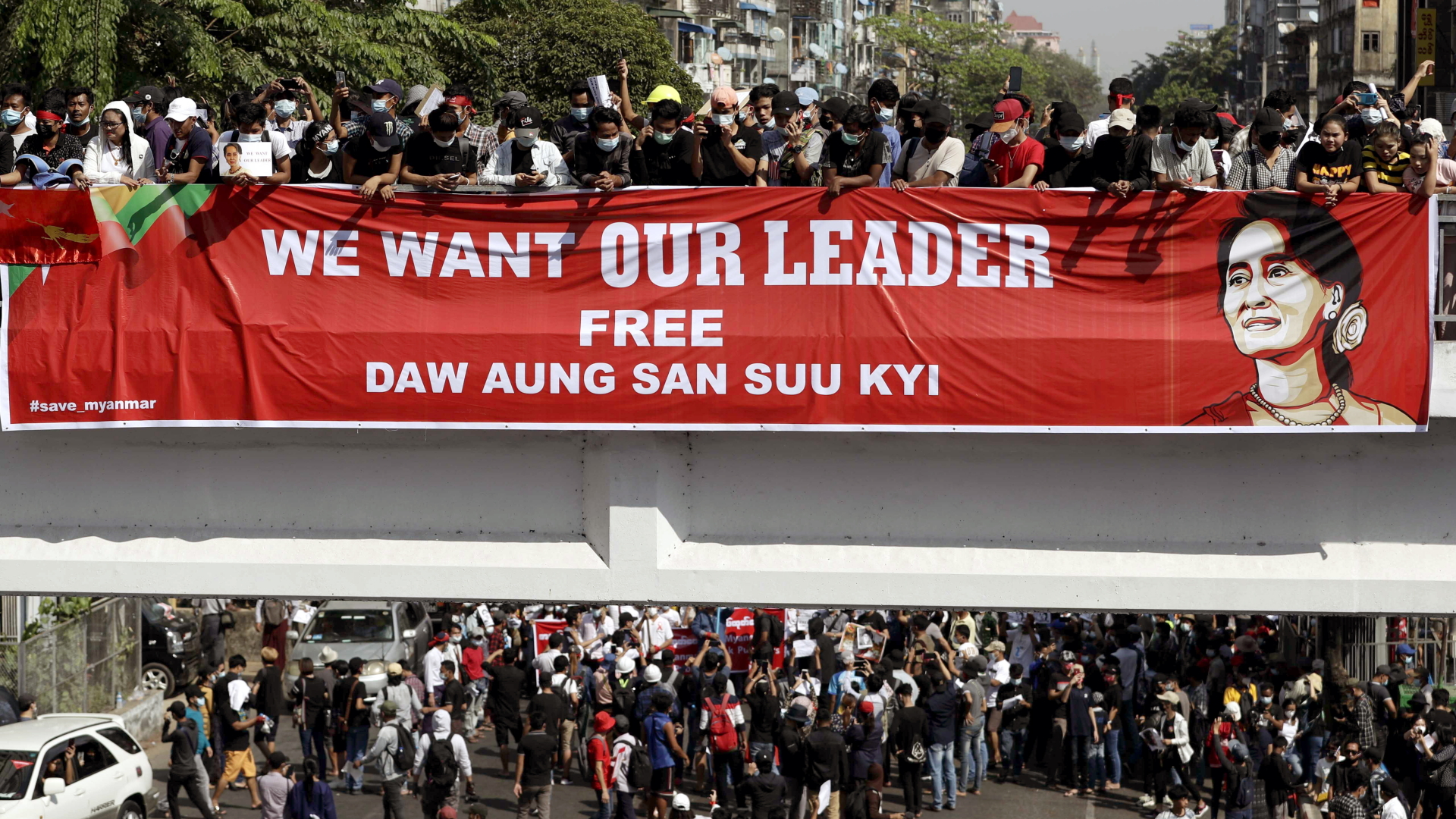 Menschen in Yangon halten ein Banner mit dem Bild von Aung San Suu Kyi von einer Brücke. | LYNN BO BO/EPA-EFE/Shutterstock