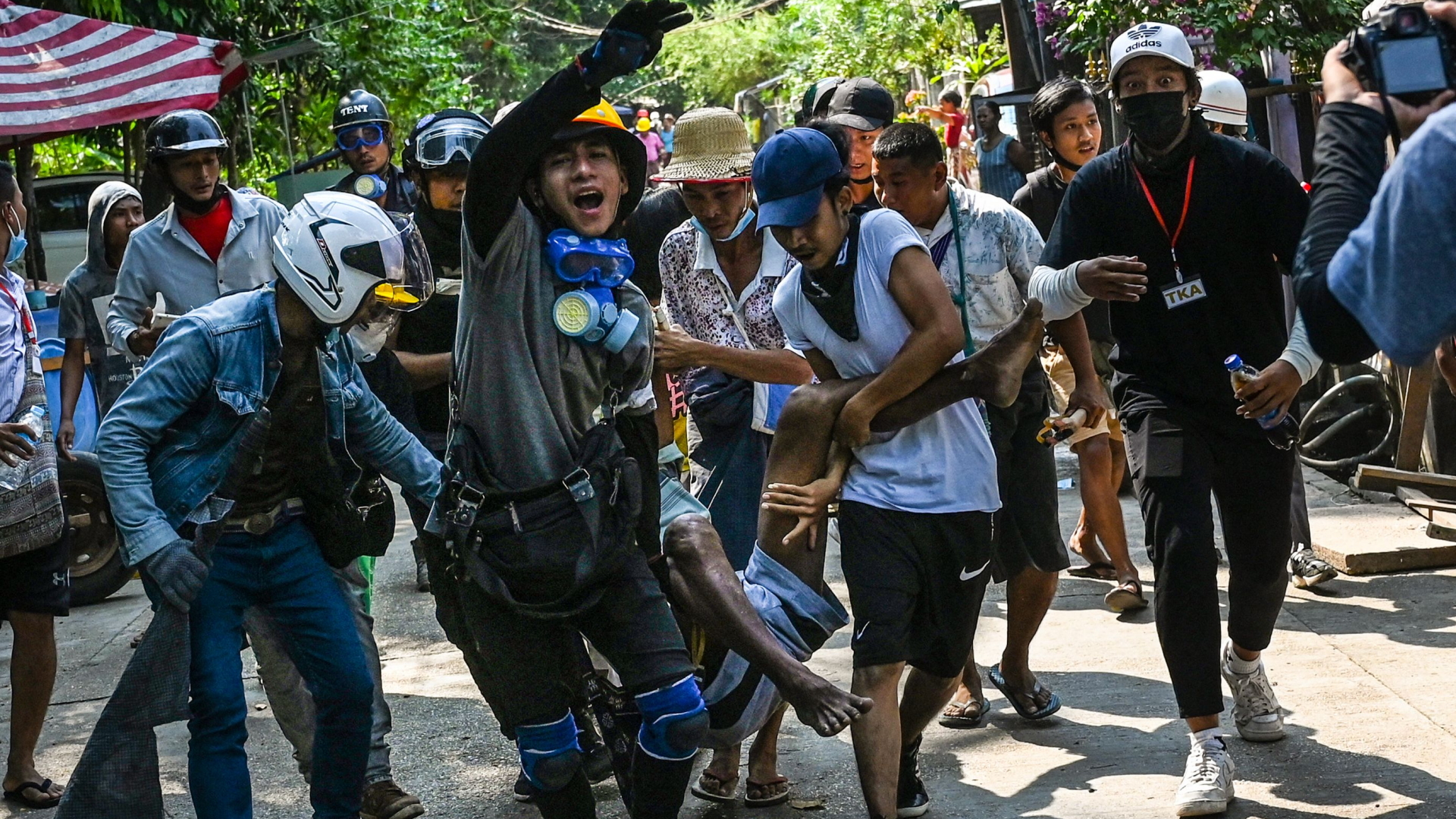 Protestierende gegen die Militärjunta in Myanmar tragen einen Verwundeten in Yangon. | AFP