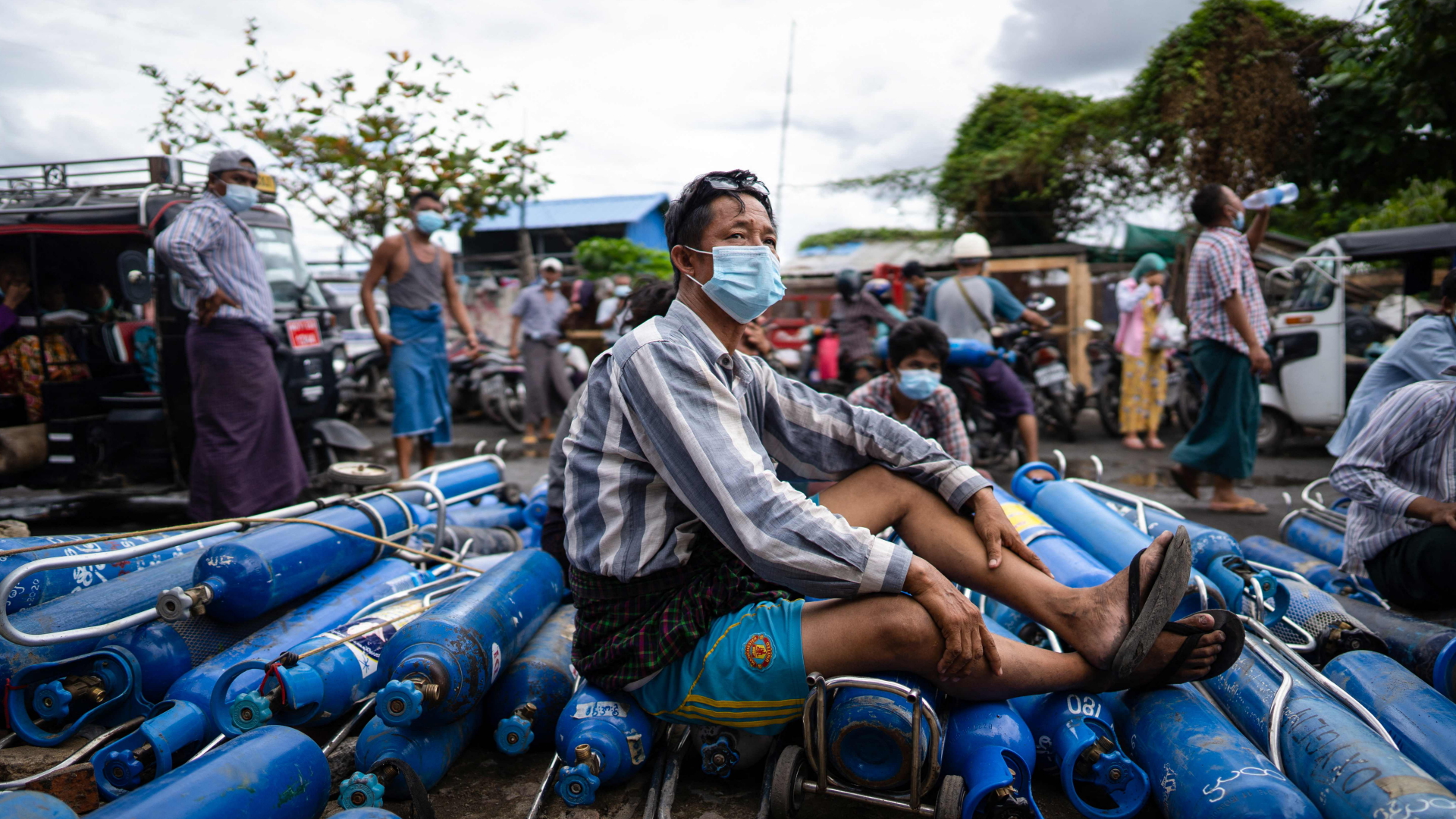 Ein Mann sitzt in Mandalay (Myanmar) auf leeren Sauerstoffflaschen | AFP