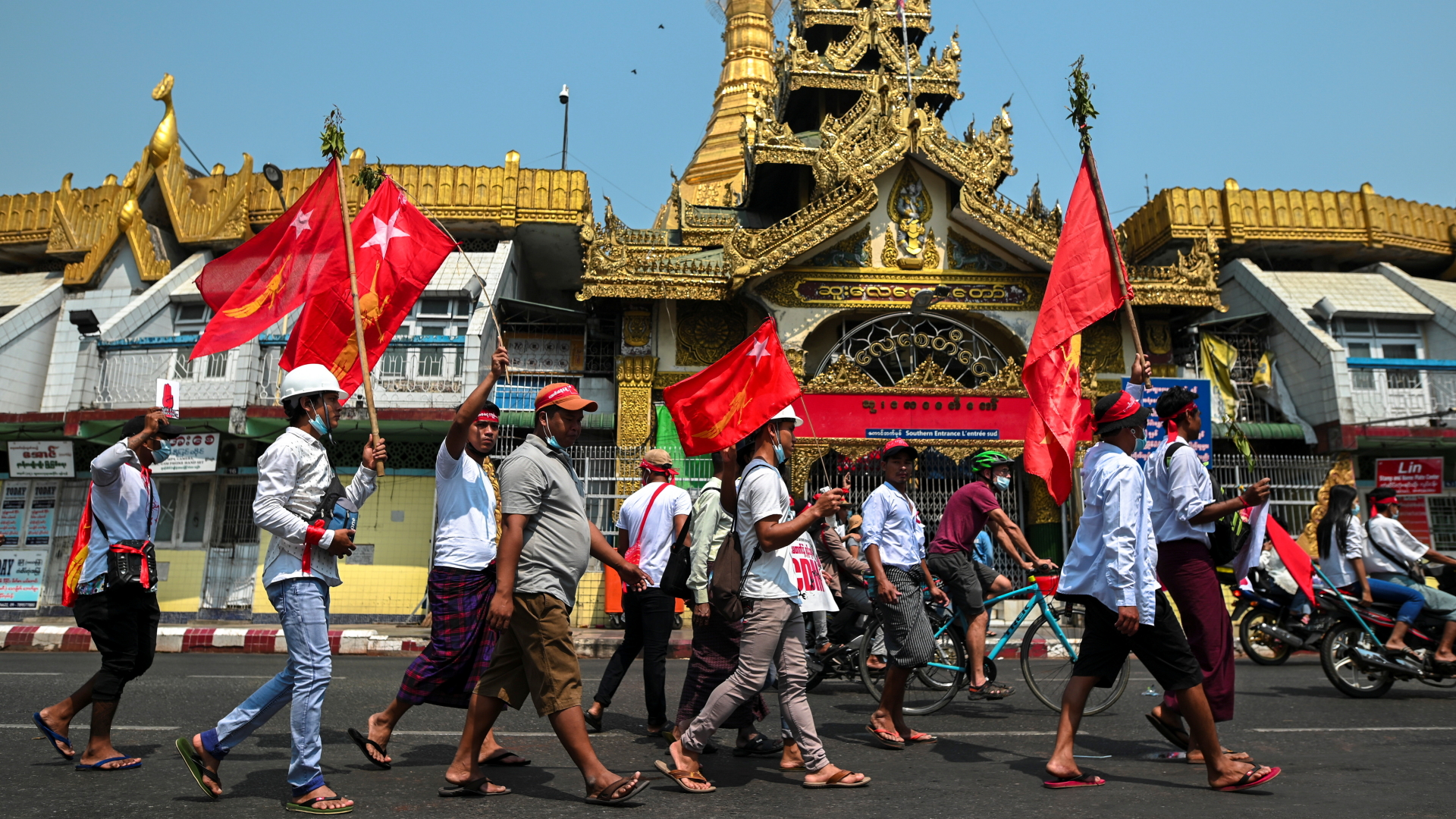 Demonstanten mit Fahnen marschieren durch die Stadt Yangon in Myanmar. | REUTERS