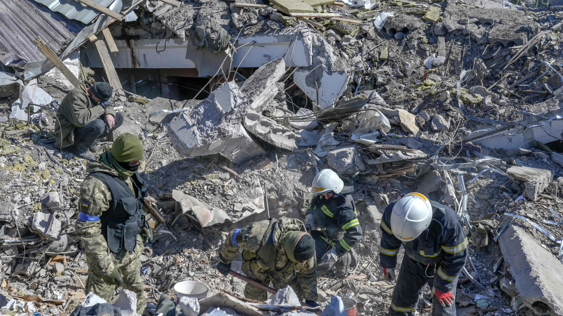 Soldaten und Rettungskräfte suchen in den Trümmern einer Kaserne in Mykolajiw nach Opfern. | AFP