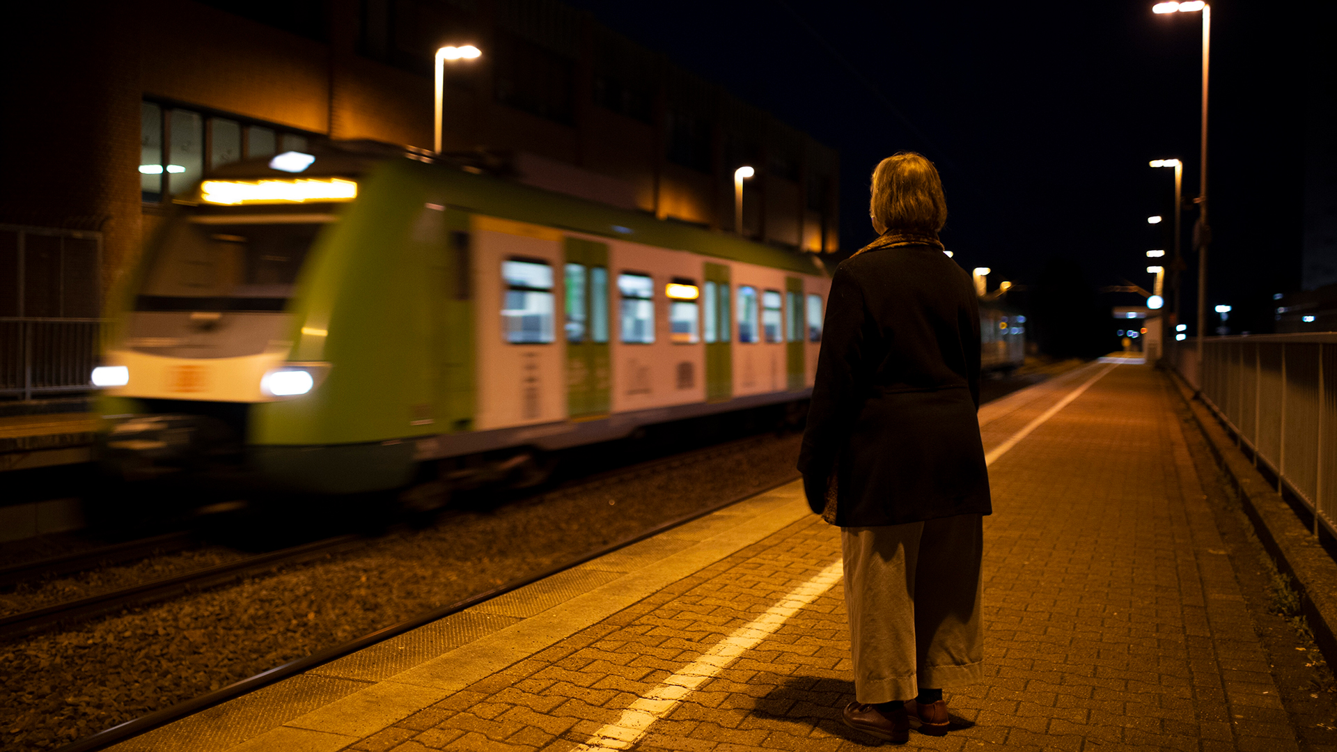 Eine Frau steht bei Dunkelheit alleine am Bahnsteig. | picture alliance / photothek