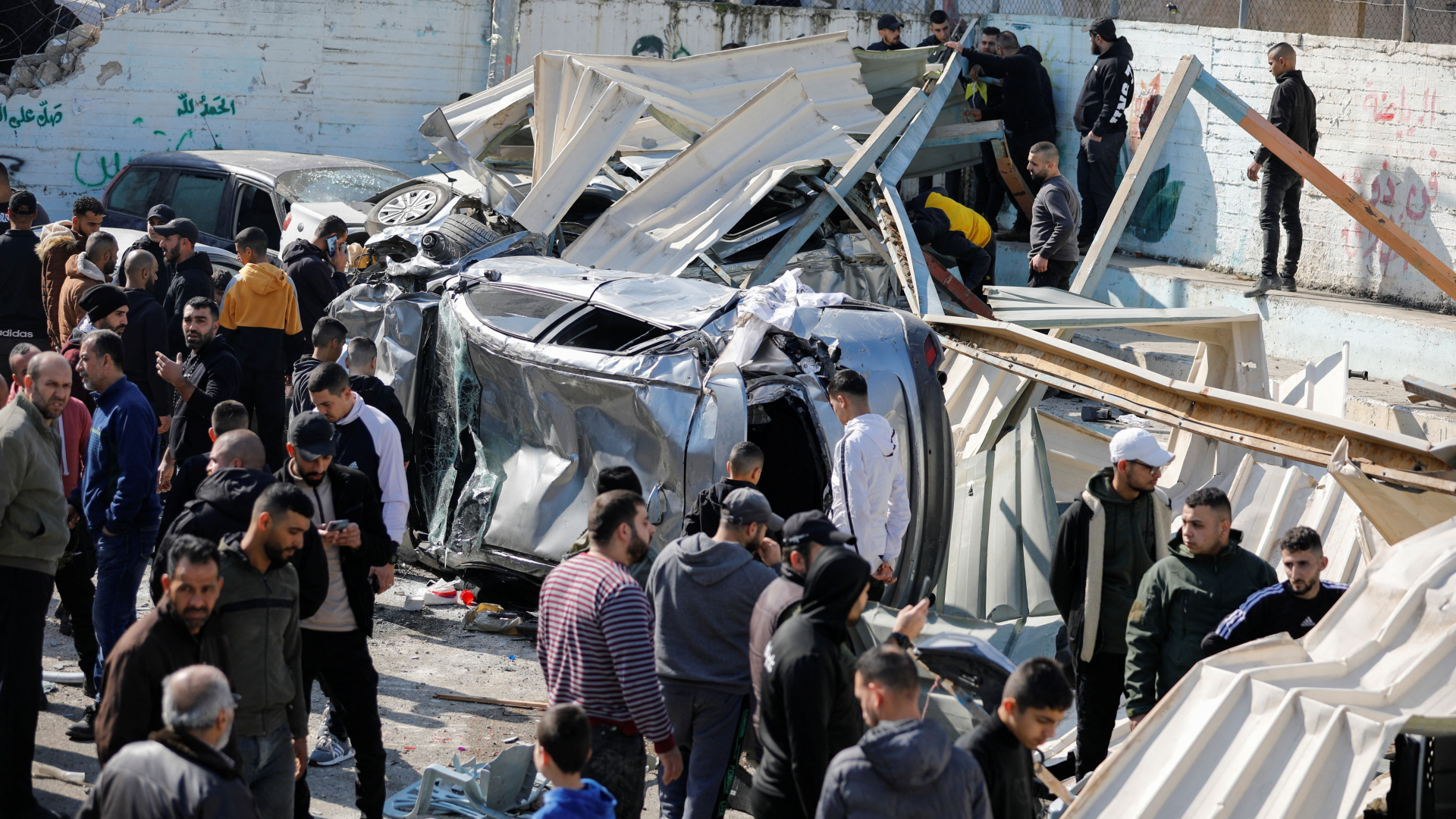 Palästinenser begutachten die Schäden an Unterkünften und Autos nach einem israelischen Militäreinsatz in Dschenin. | REUTERS
