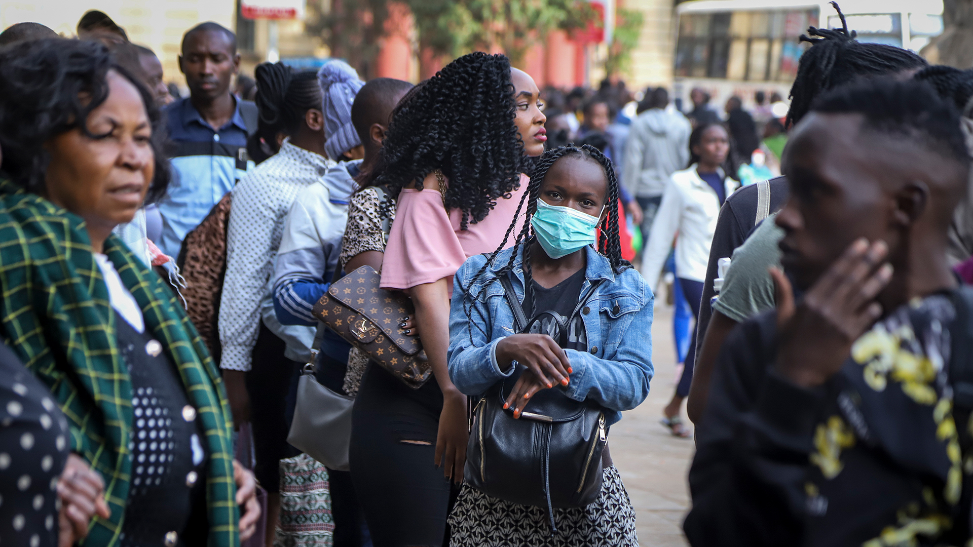 Eine Frau trägt eine Gesichtsmaske auf einer belebten Straße in der Innenstadt von Nairobi | Bildquelle: dpa