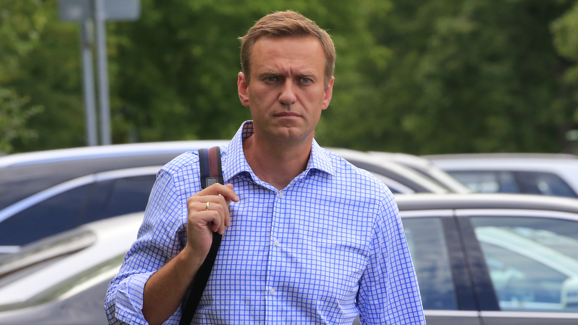 Der Kreml-Kritiker Alexej Nawalny trägt einen Rucksack und läuft über einen Parkplatz.