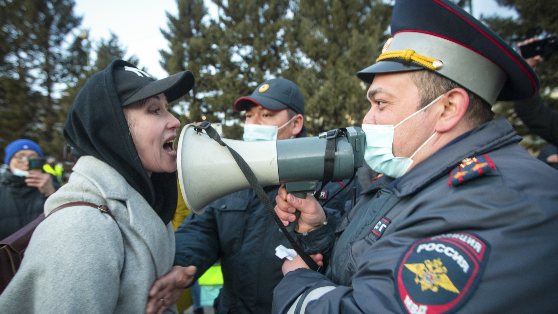 Eine Teilnehmerin einer Demonstration von Nawalny-Unterstützern in Ulan-Ude steht einem Polizisten gegenüber | AP
