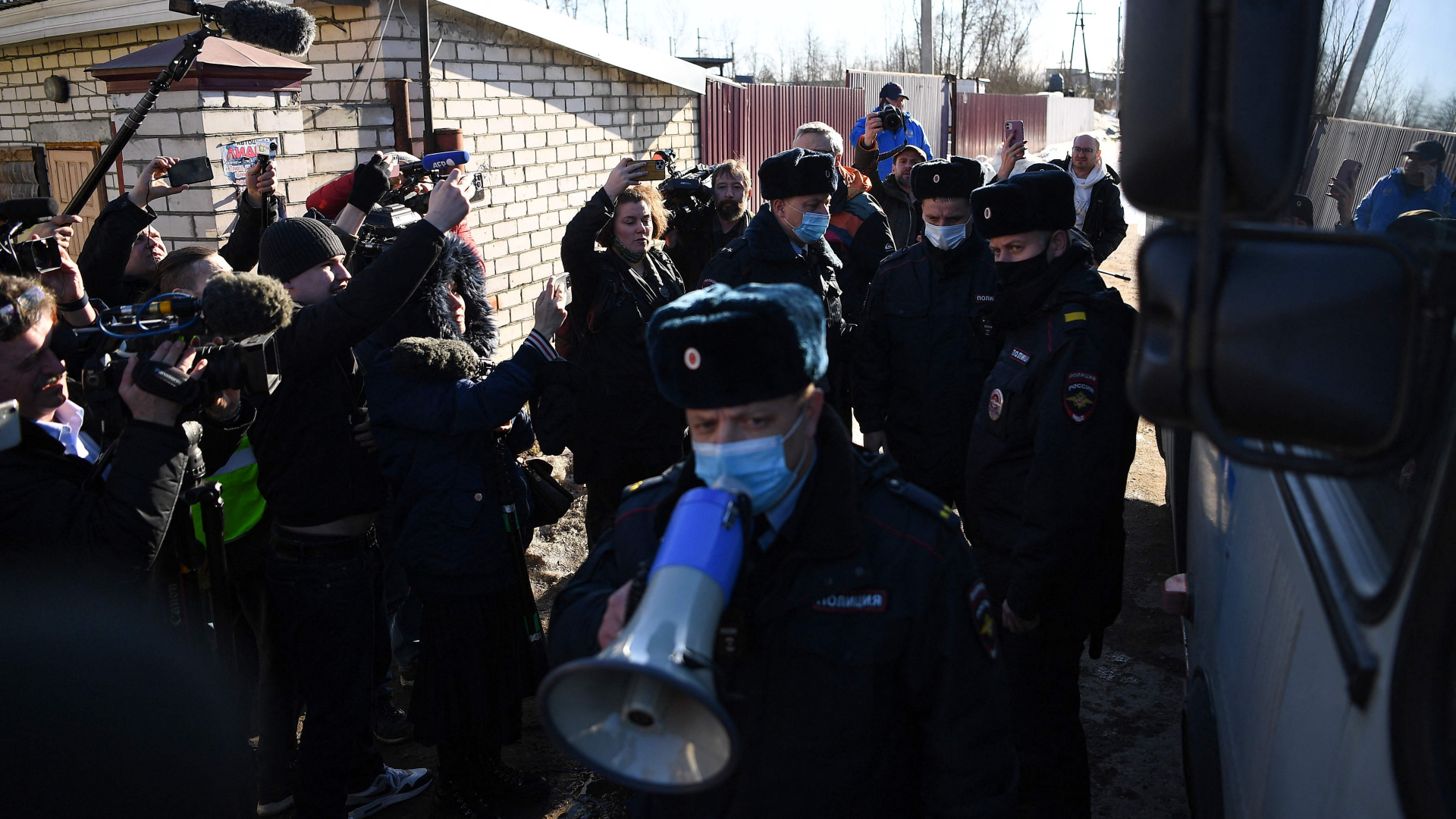 Ein Polizist fordert die Journalisten mit einem Megafon auf, die Versammlung aufzulösen | AFP