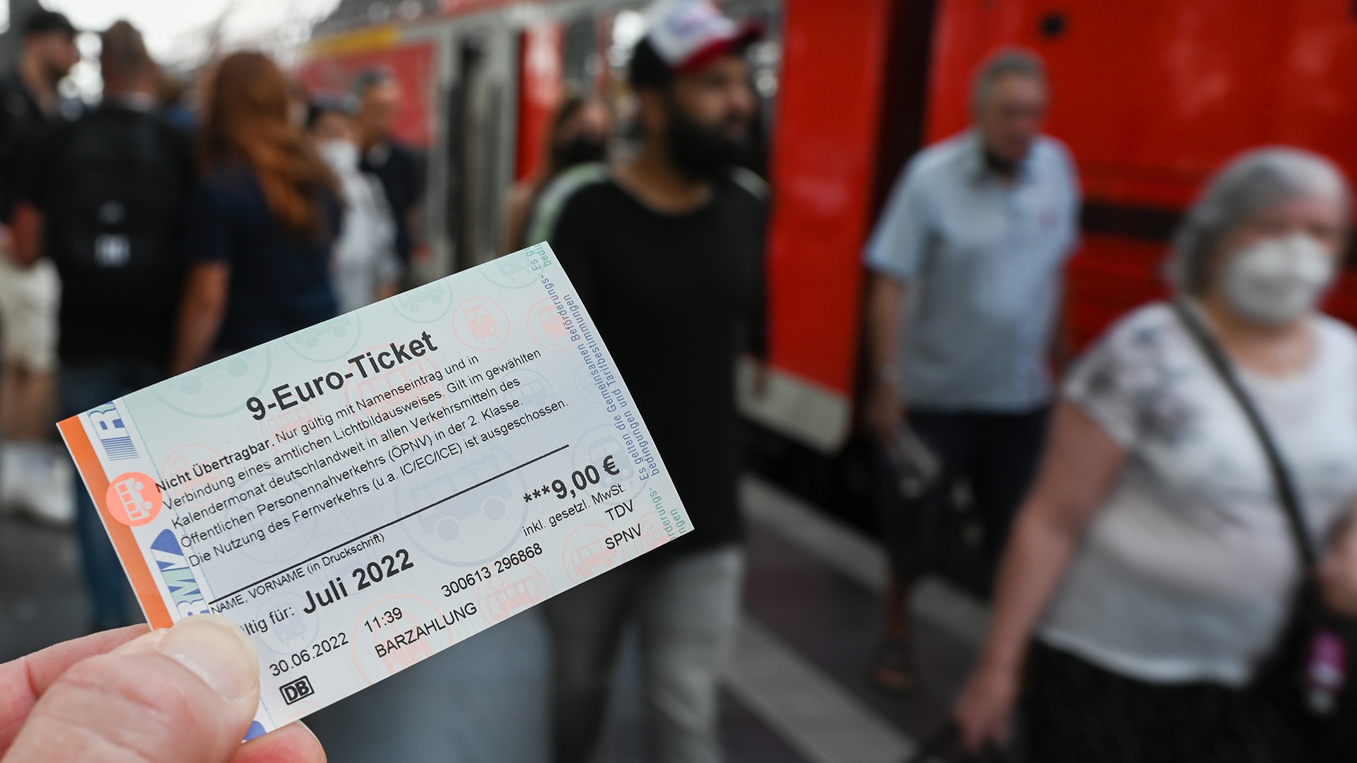 Eine Person hält ein 9-Euro-Ticket in der Hand. | picture alliance/dpa/Arne Dedert