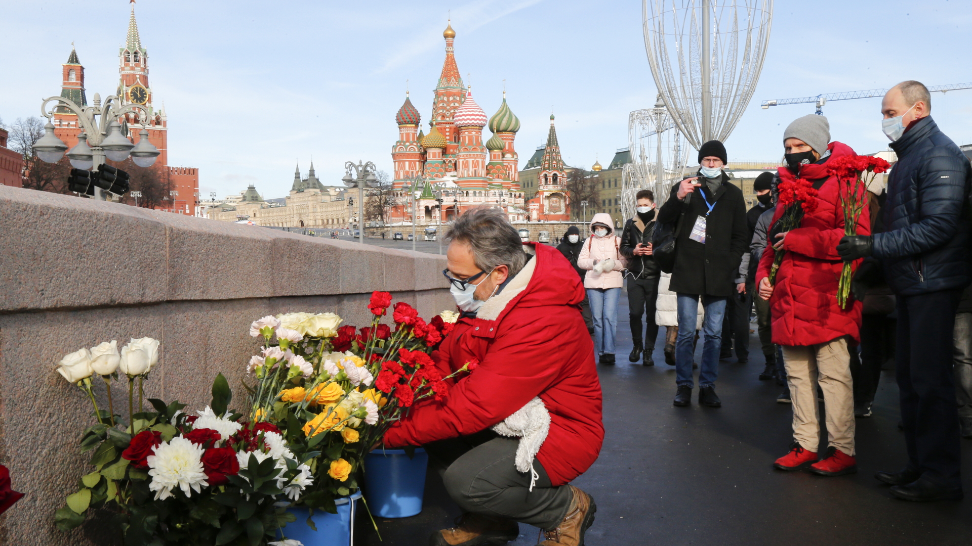 Menschen legen Blumen am Ort des Anschlags auf Nemzow nahe des Kreml nieder. | dpa