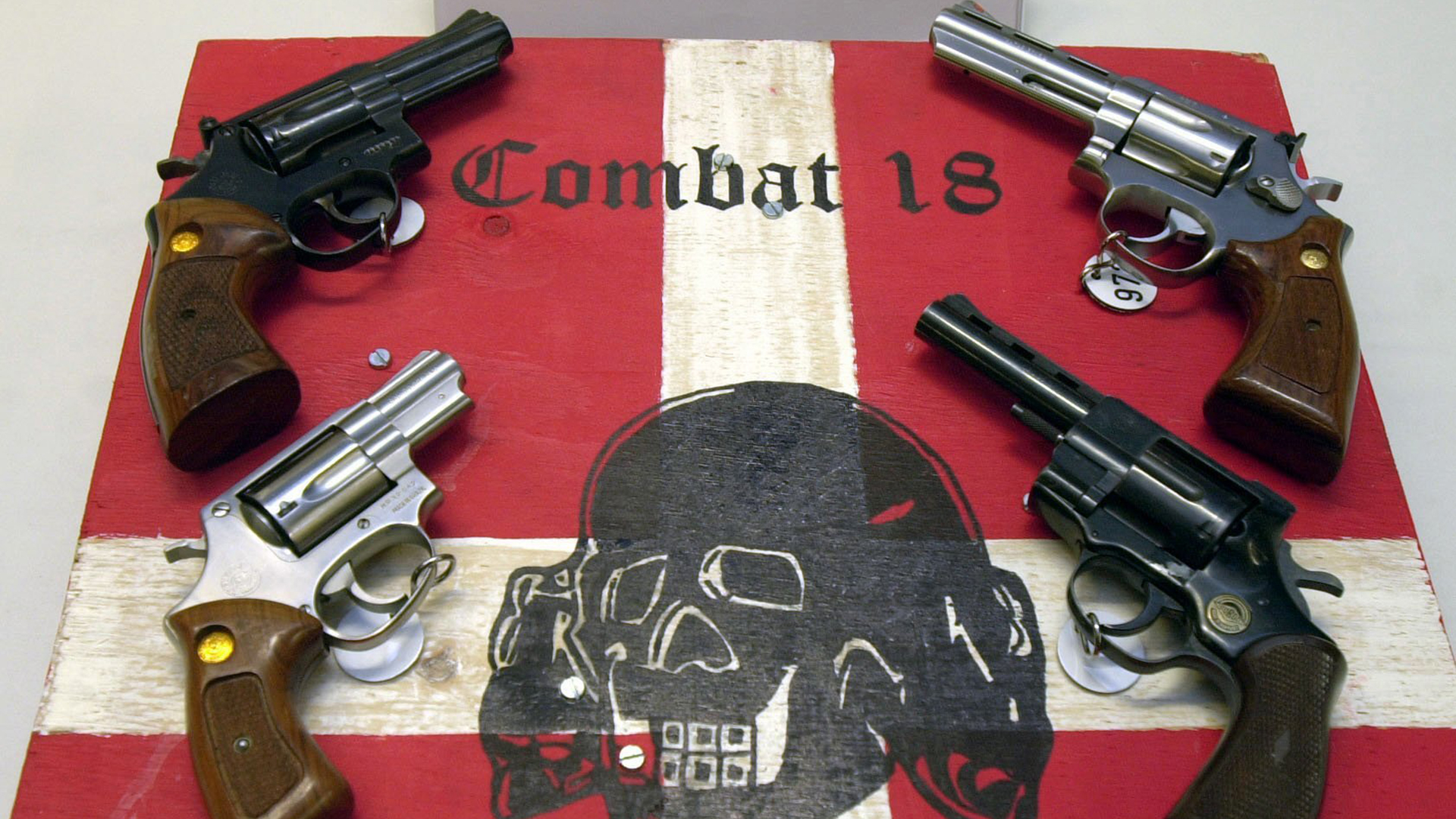 Waffen und ein sichergestelltes Schild der Neonazi Gruppierung ''Combat 18''