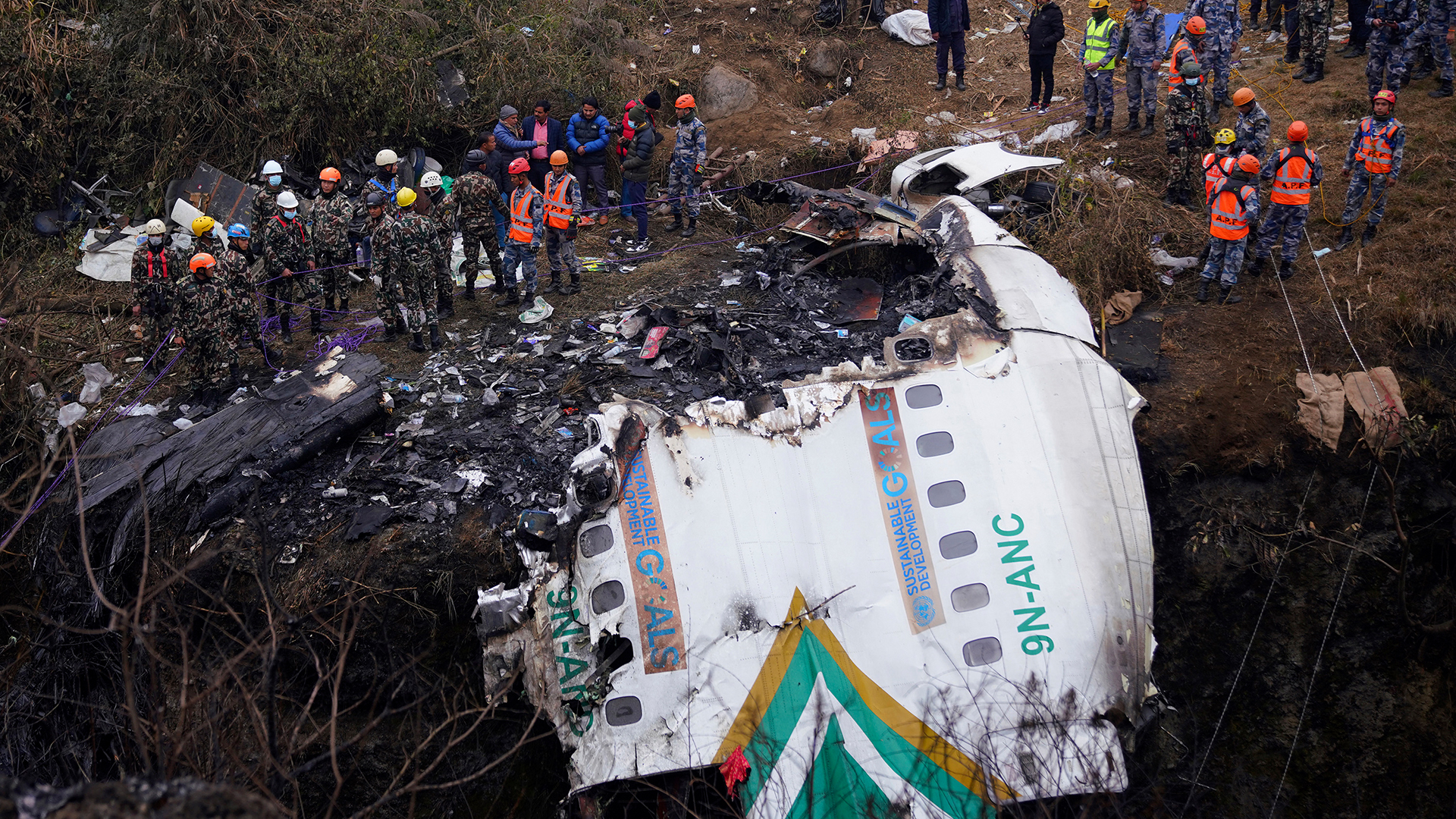 Retter ziehen die Leiche eines Opfers, das bei einem Flugzeugabsturz der Yeti Airlines in Pokhara ums Leben kam | AFP
