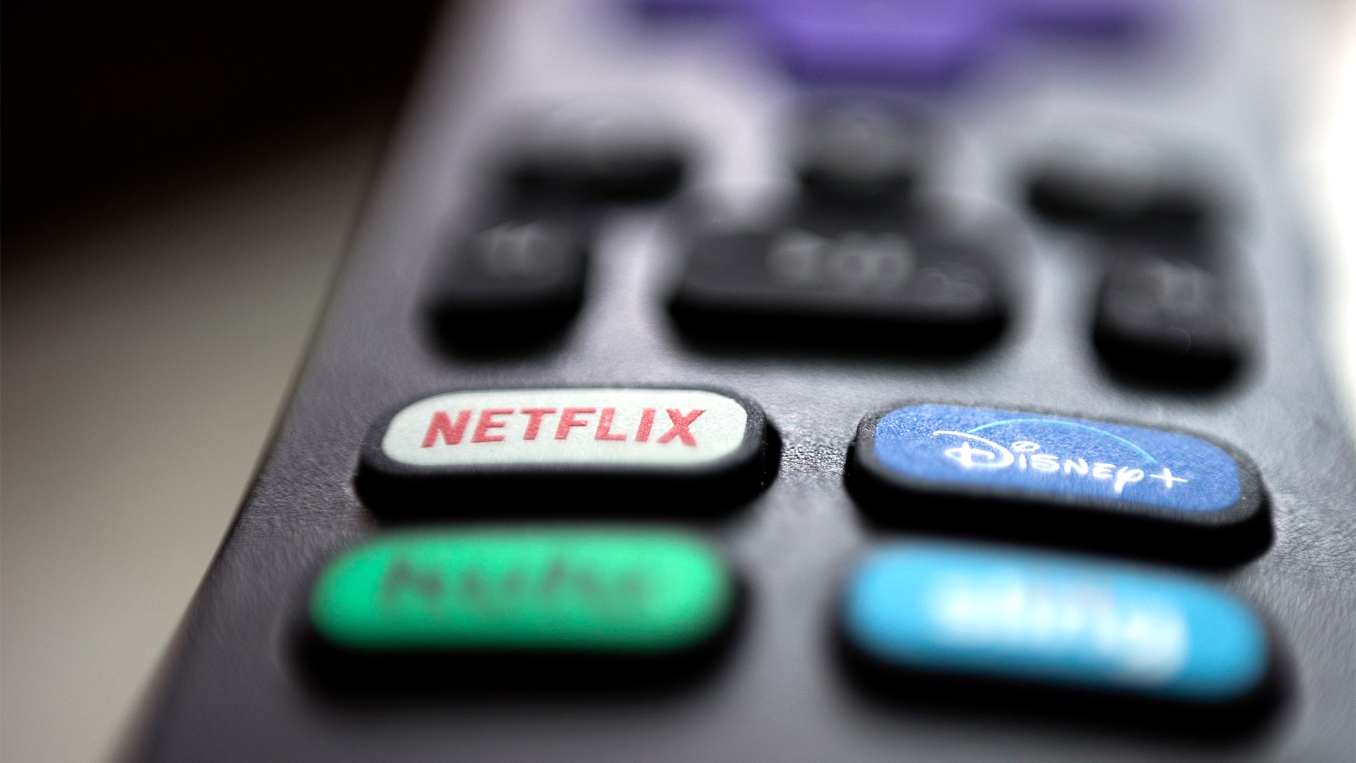 Logos von Netflix und Disney auf einer TV-Fernbedienung | picture alliance / ASSOCIATED PR
