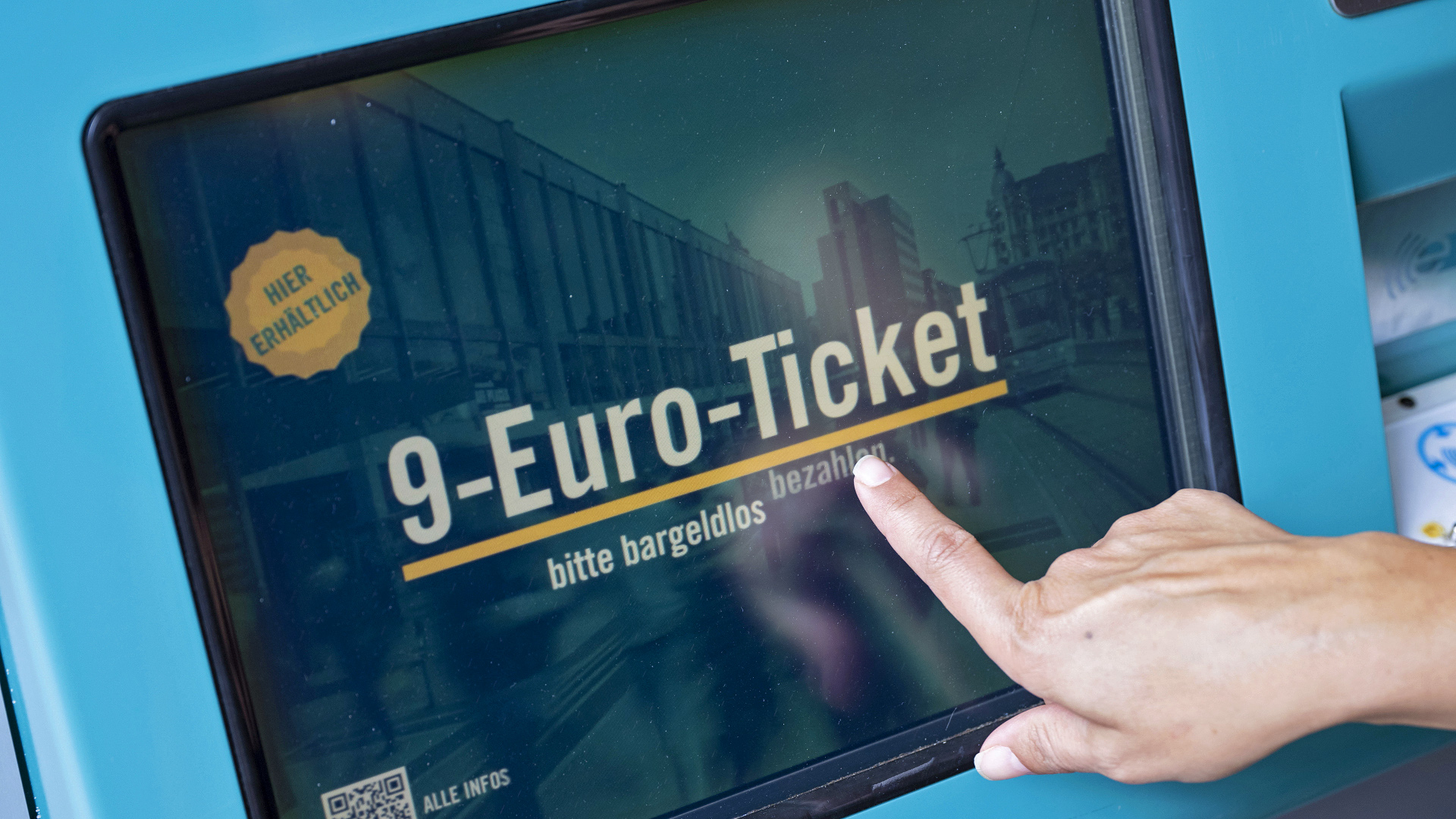 Eine Frau zieht in Frankfurt am Main an einem Fahrschein-Automaten ein 9-Euro-Ticket
