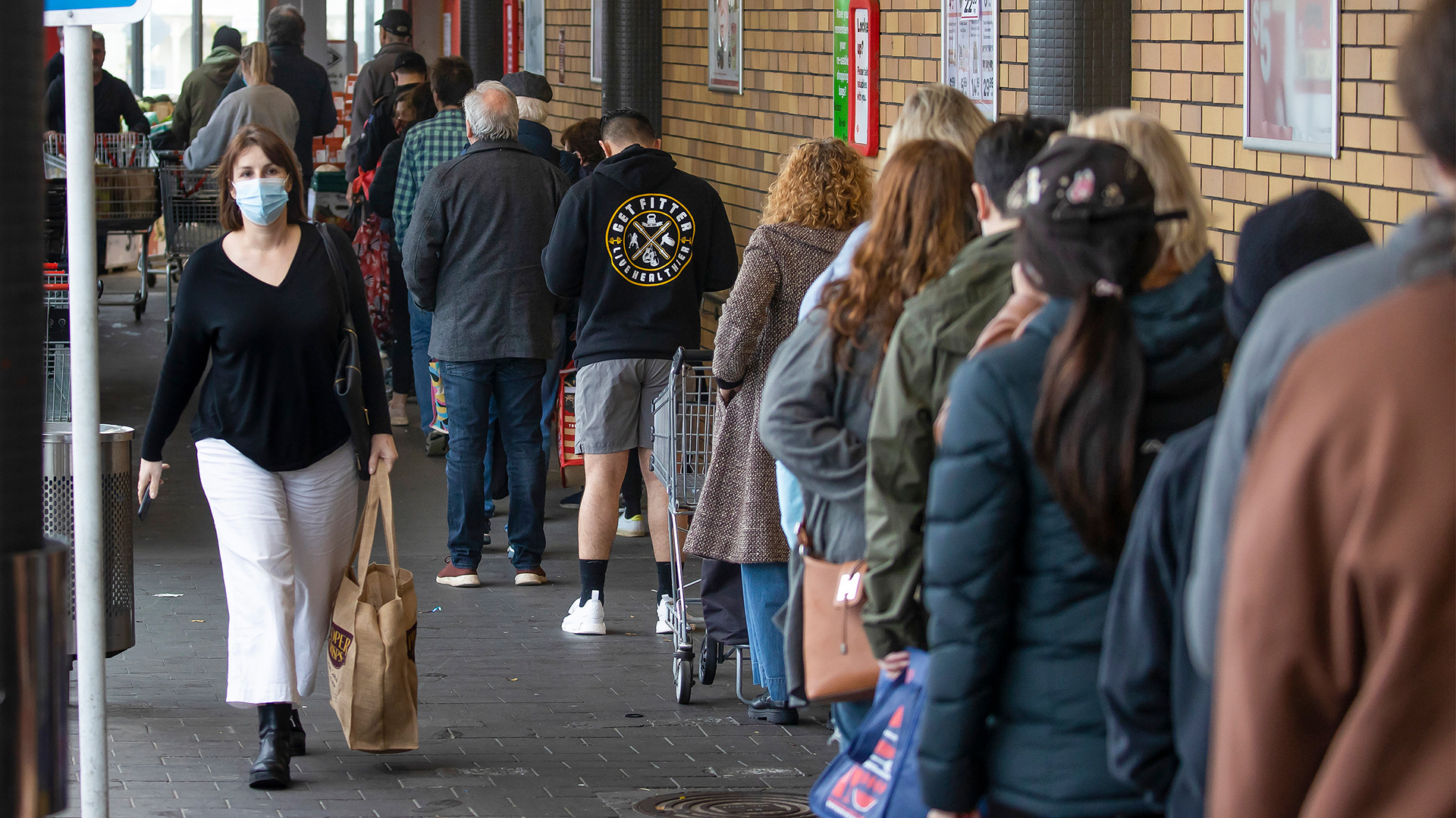 Menschen stehen Schlange vor einem Supermarkt in Auckland (Neuseeland). | AP
