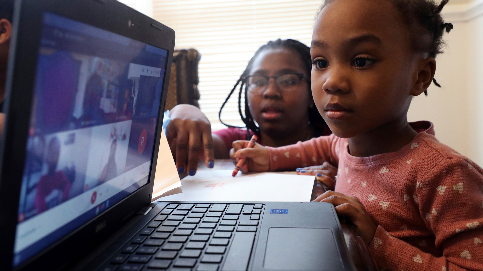 Eine Mutter hilft ihrer Tochter bei den Schulaufgaben vor einem PC. | AP