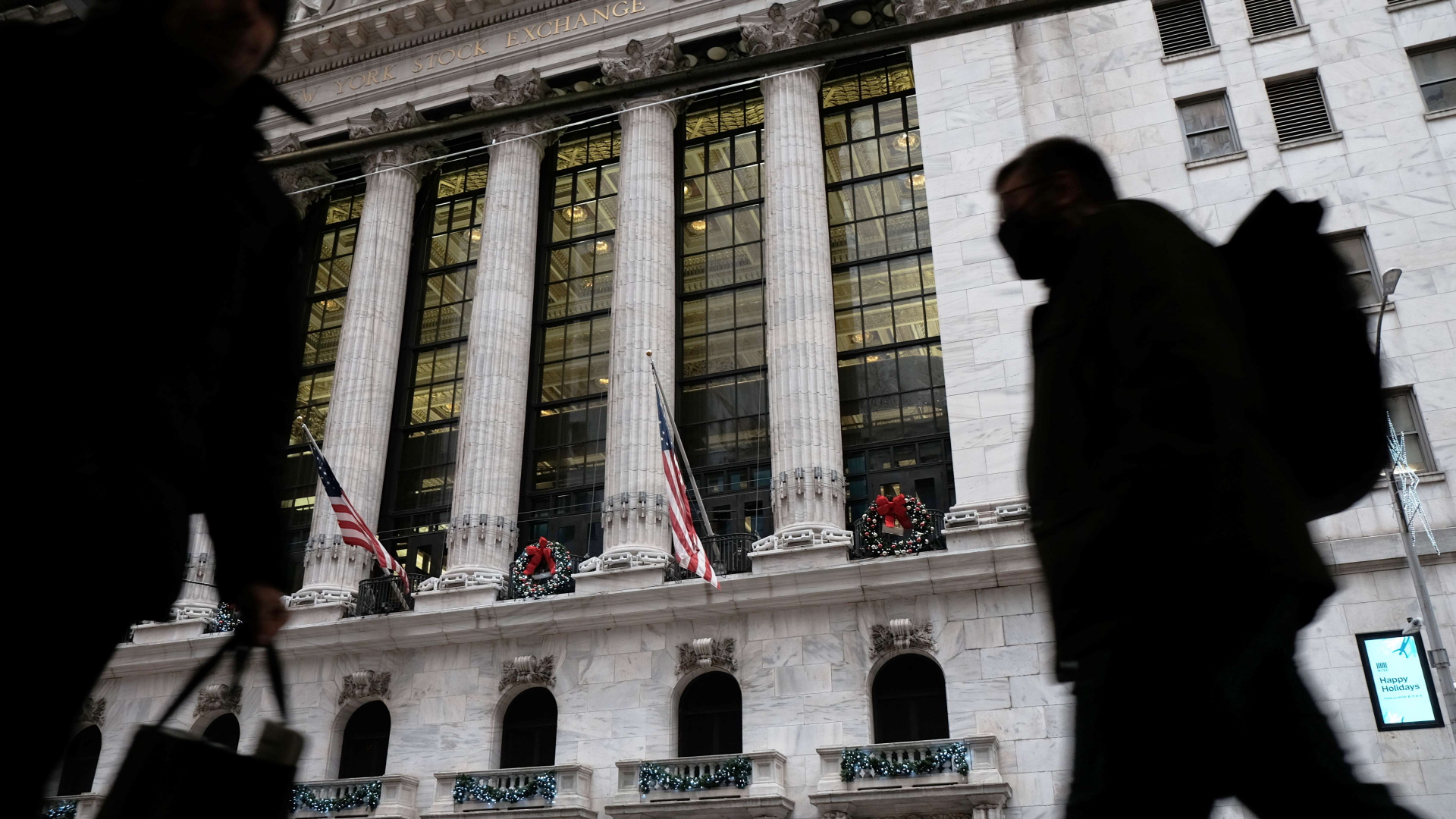 Menschen laufen vor der Gebäude des New York Stock Exchange vorbei. | AFP